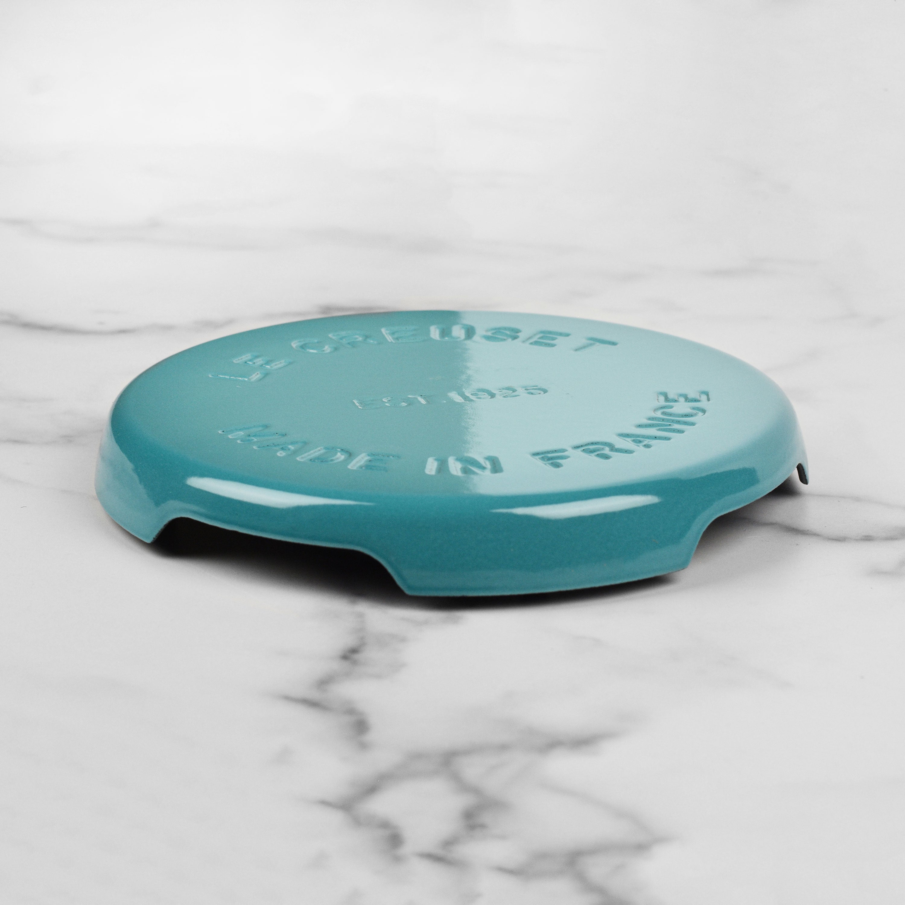 Close-up of the durable enamel finish of the Le Creuset trivet, highlighting its quality.