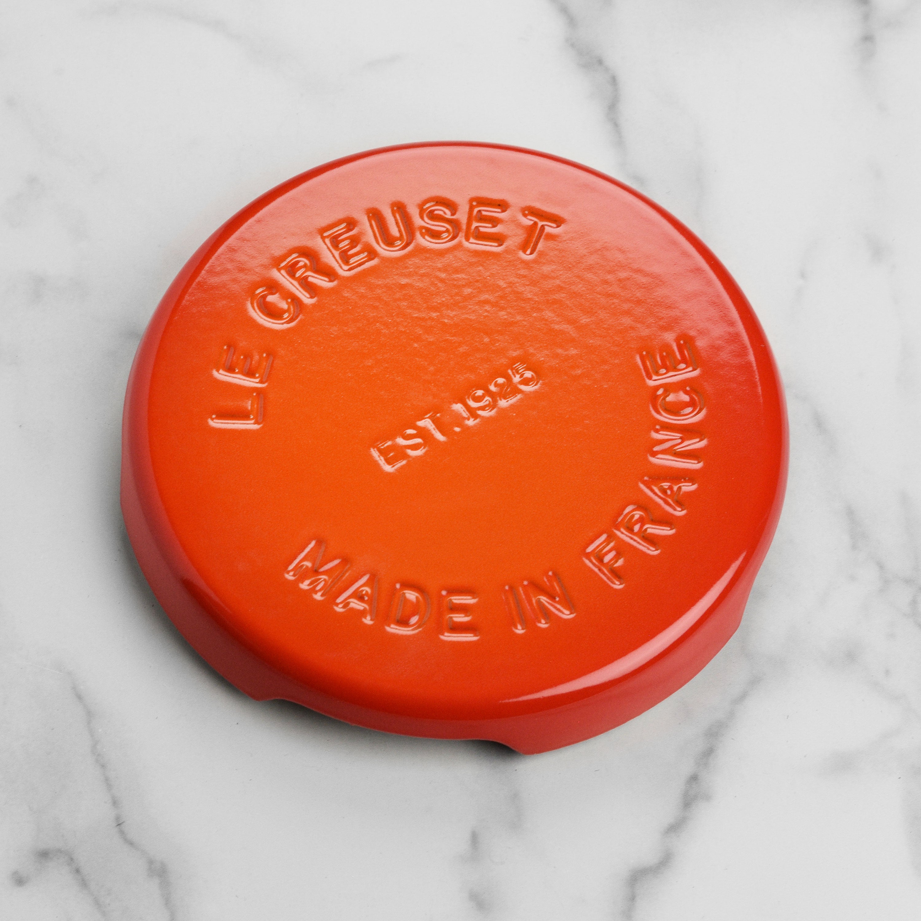 Le Creuset flame cast iron trivet in a modern kitchen setting