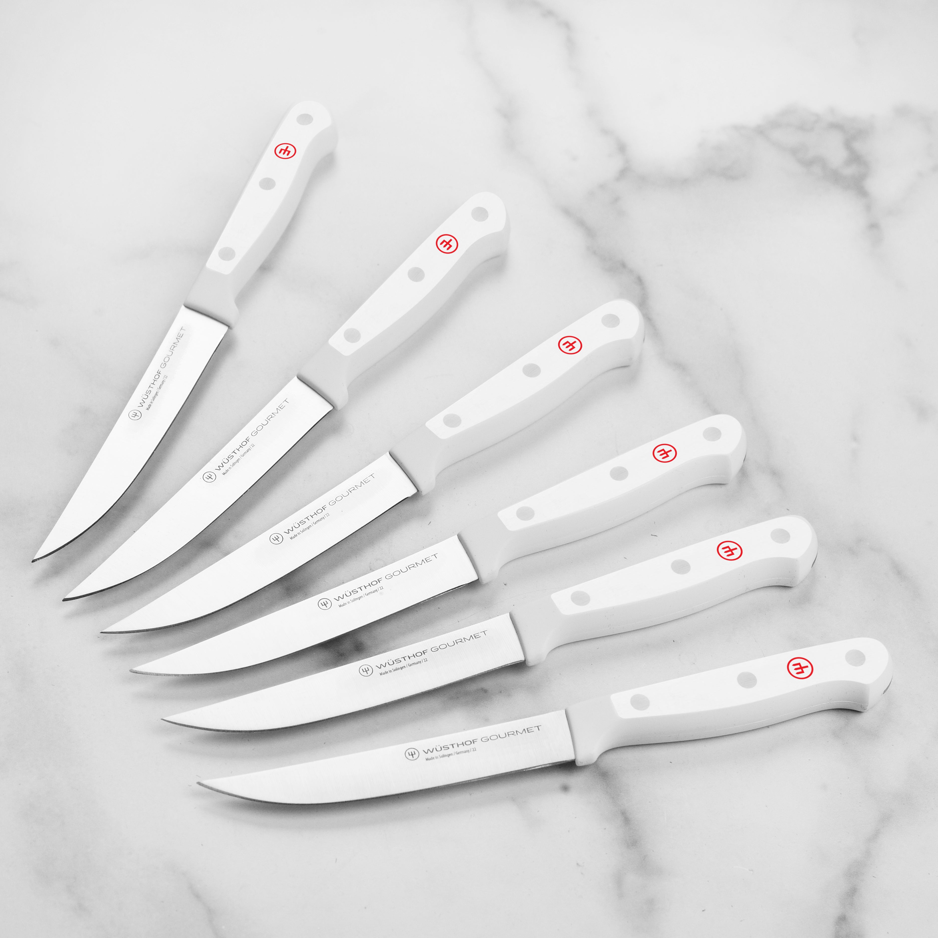 High-carbon steel Wusthof knives with white handles in a kitchen setting