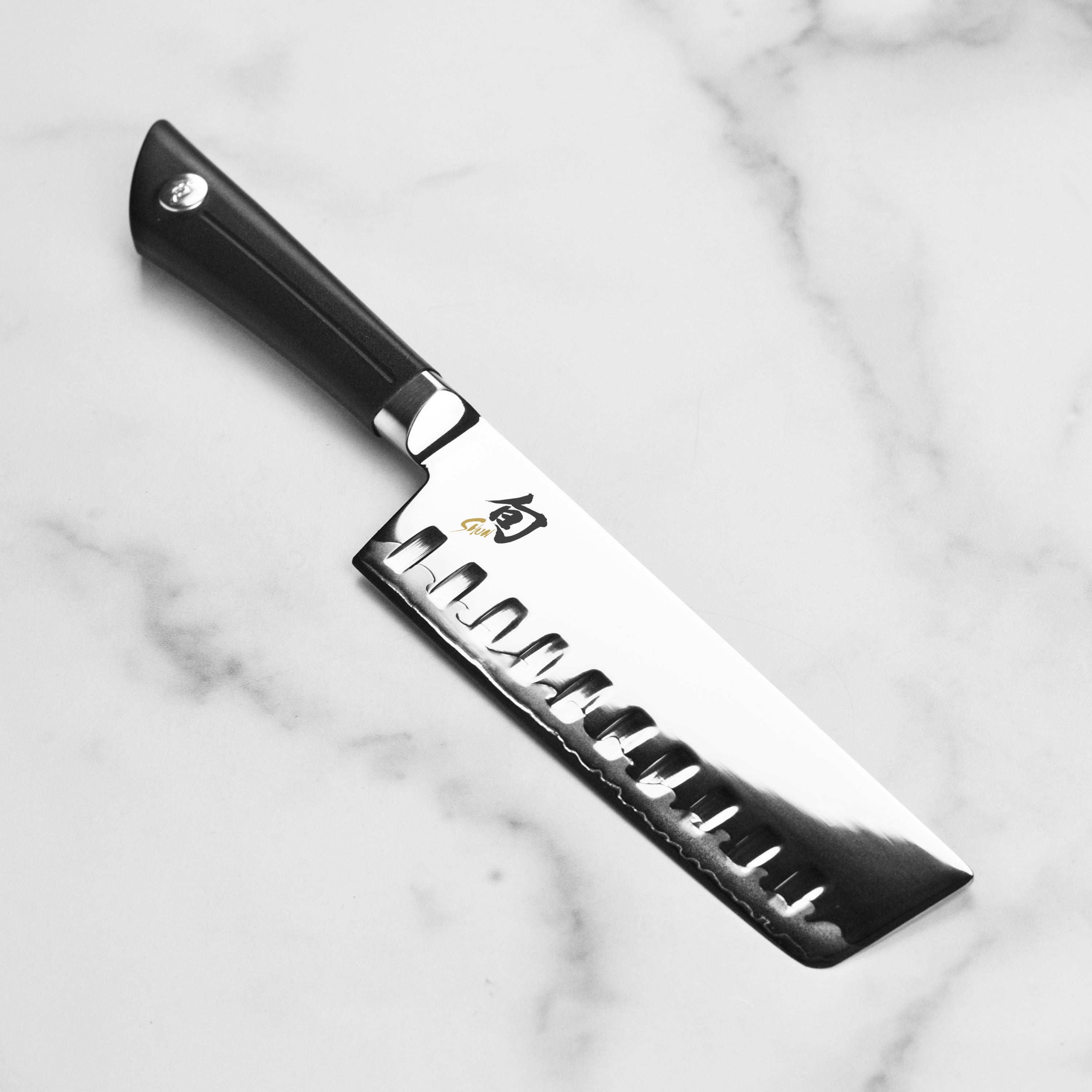 Shun Sora Nakiri knife with a detailed view of the blade and handle, designed for precision cutting in the kitchen.