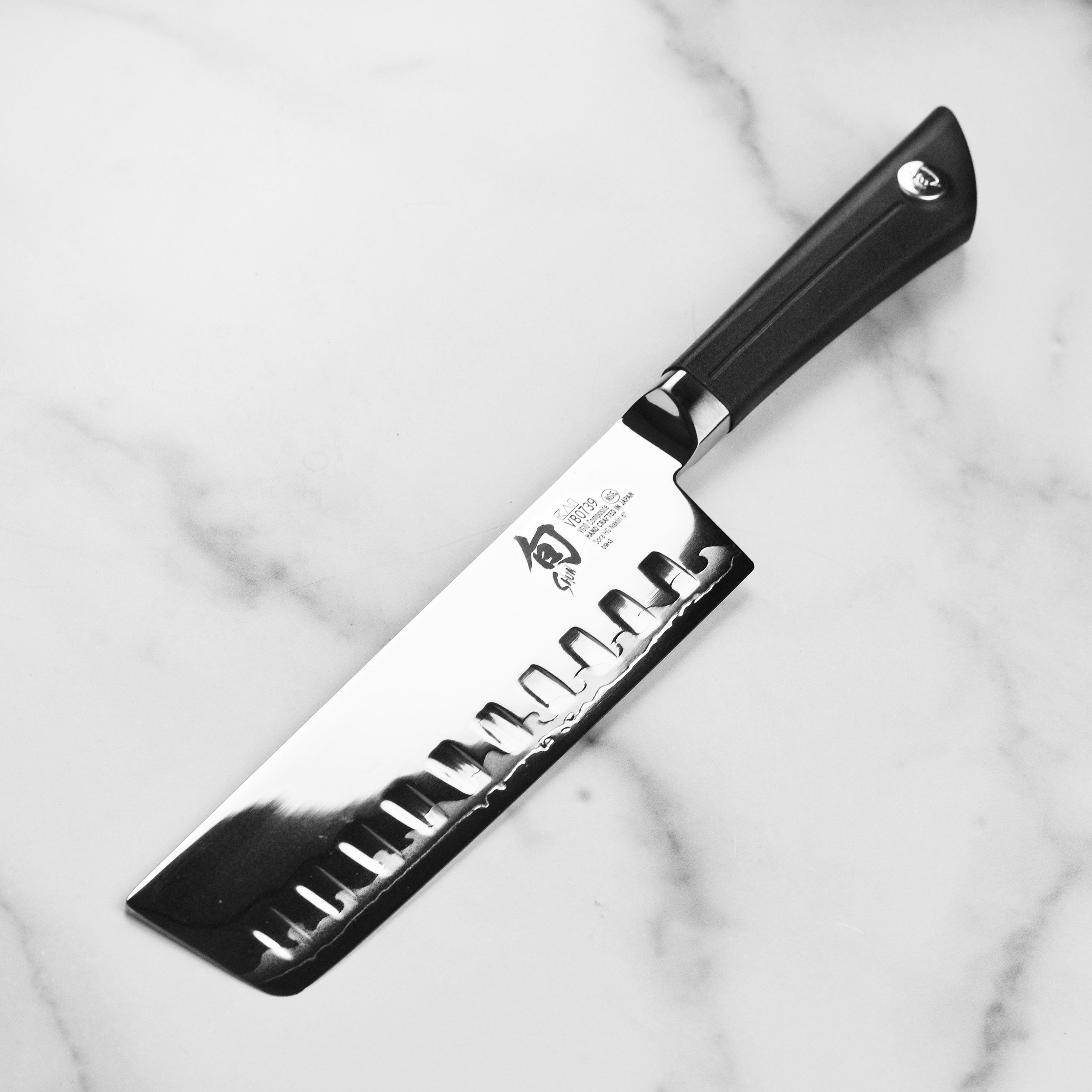 A side profile of the Shun Sora 6-inch Nakiri knife, highlighting the unique san mai edge and traditional Japanese craftsmanship.