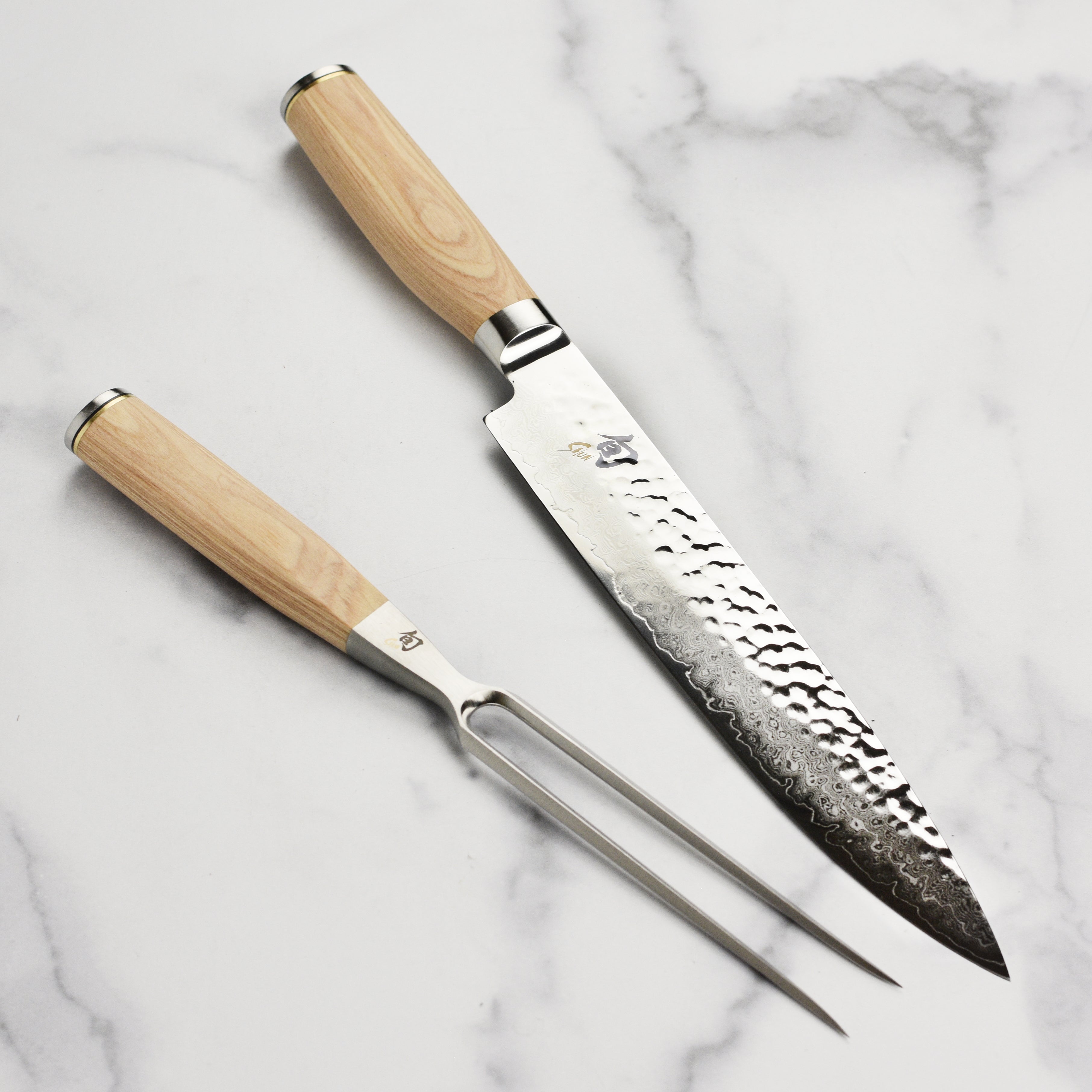 Shun Premier Blonde carving set displayed on a wooden cutting board, highlighting the blade's sharpness and finish.