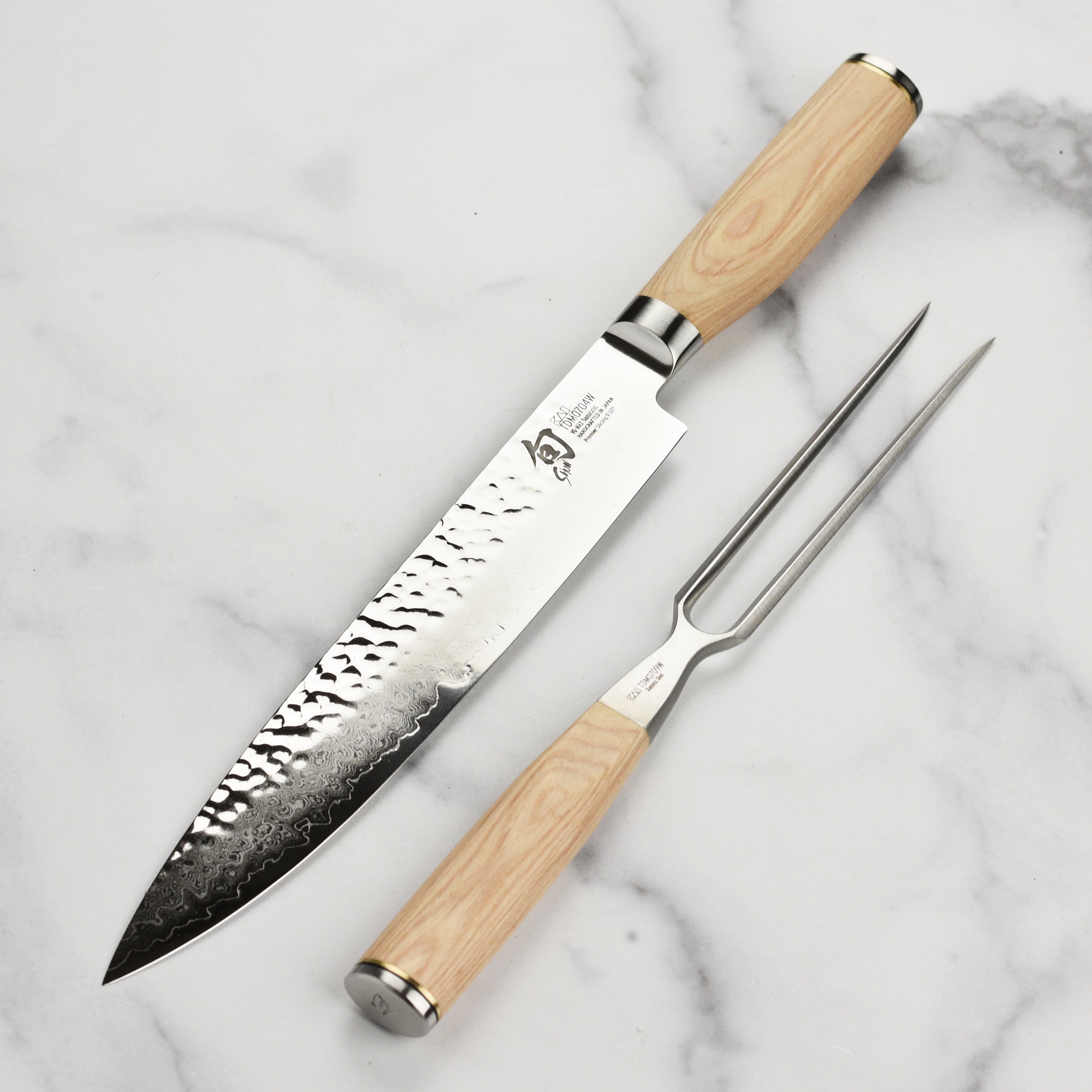 Shun Premier Blonde carving set displayed on a wooden cutting board, highlighting the blades sharpness and finish.