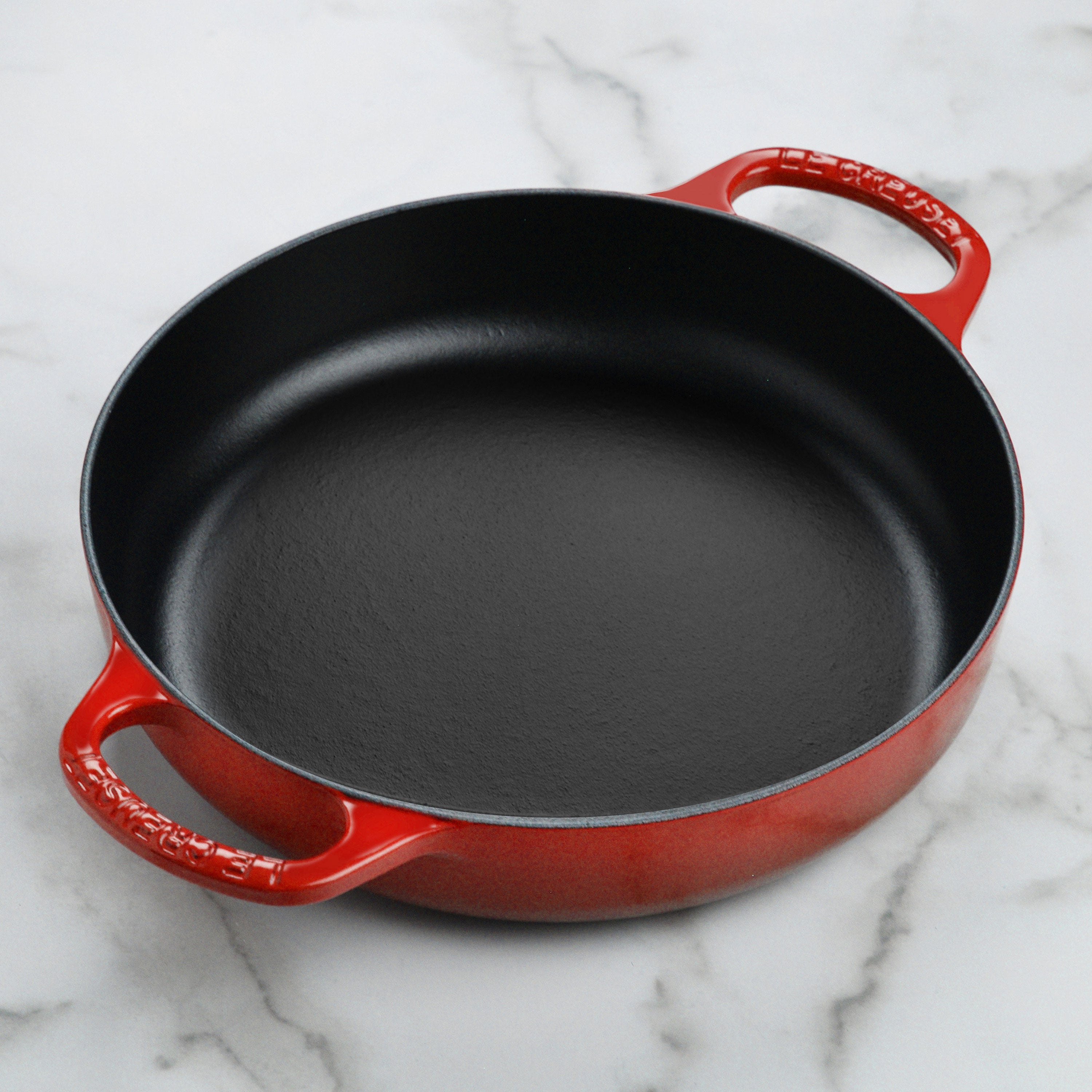 Close-up view of the black satin interior of the Le Creuset cast iron pan, highlighting its cooking performance.