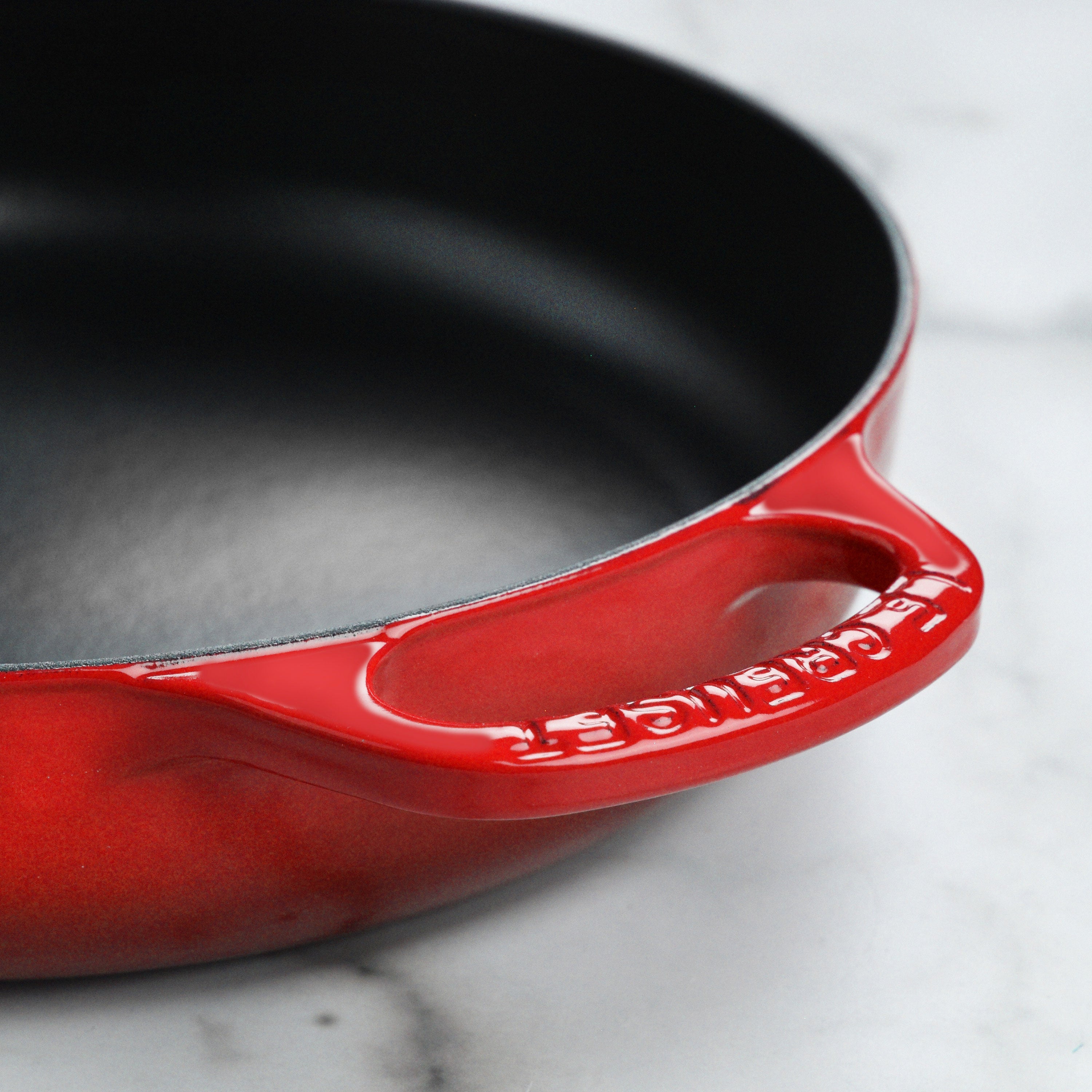 Le Creuset 11 inch cerise everyday pan showcasing its enameled finish and wide-loop handles.