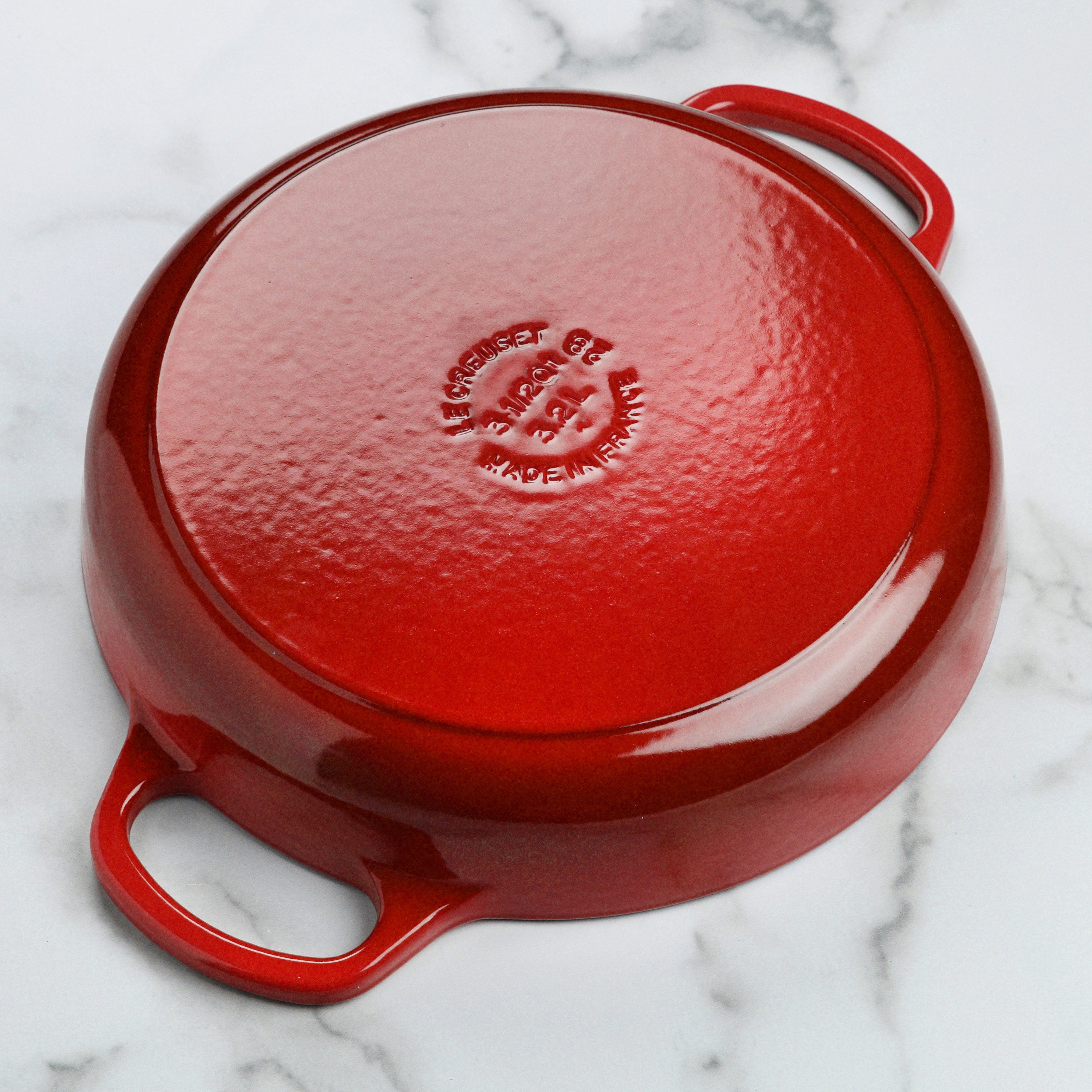 Le Creuset 11 inch cerise everyday pan showcasing its enameled finish and wide-loop handles.