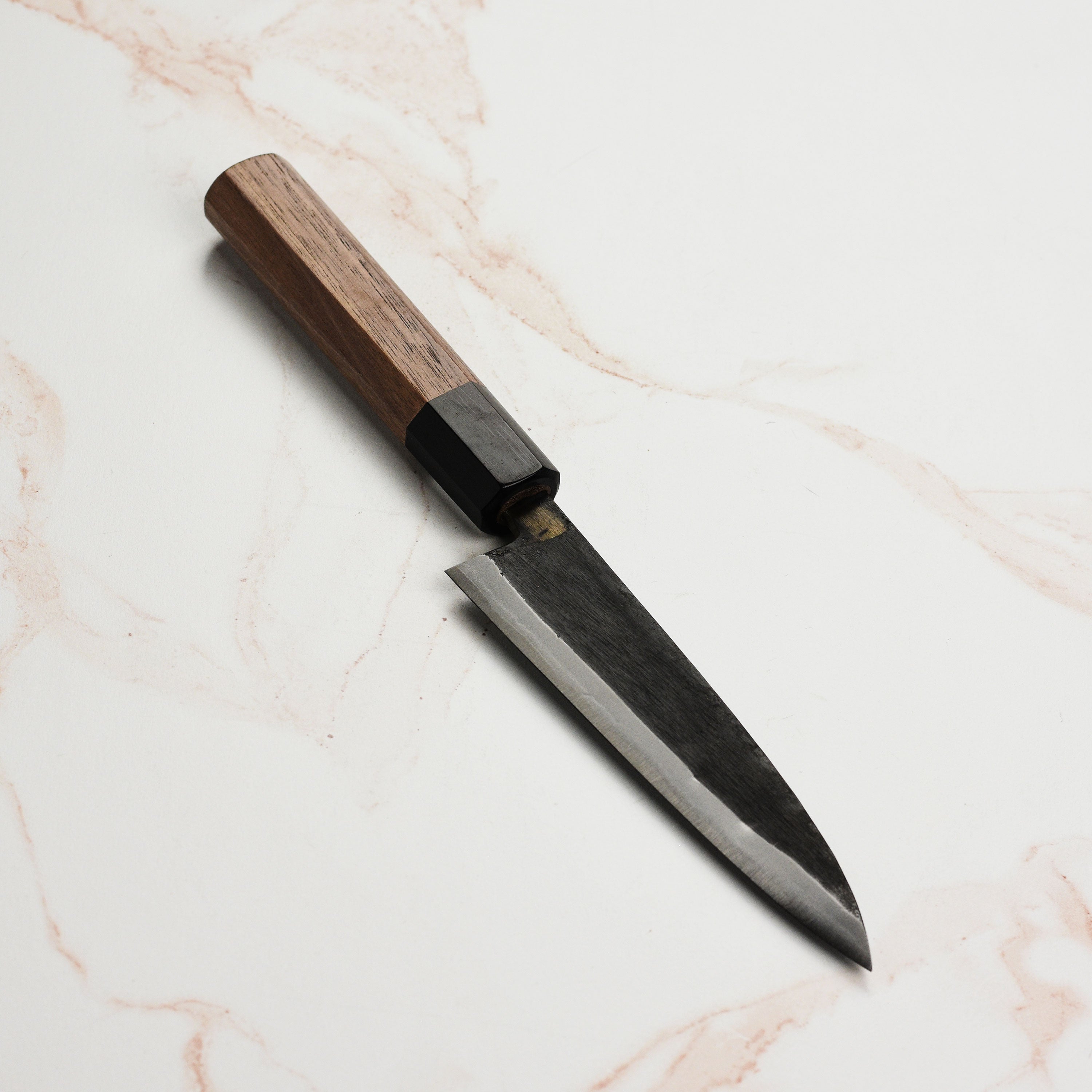 Side angle of the Moritaka petty knife demonstrating its sharp edge and craftsmanship.