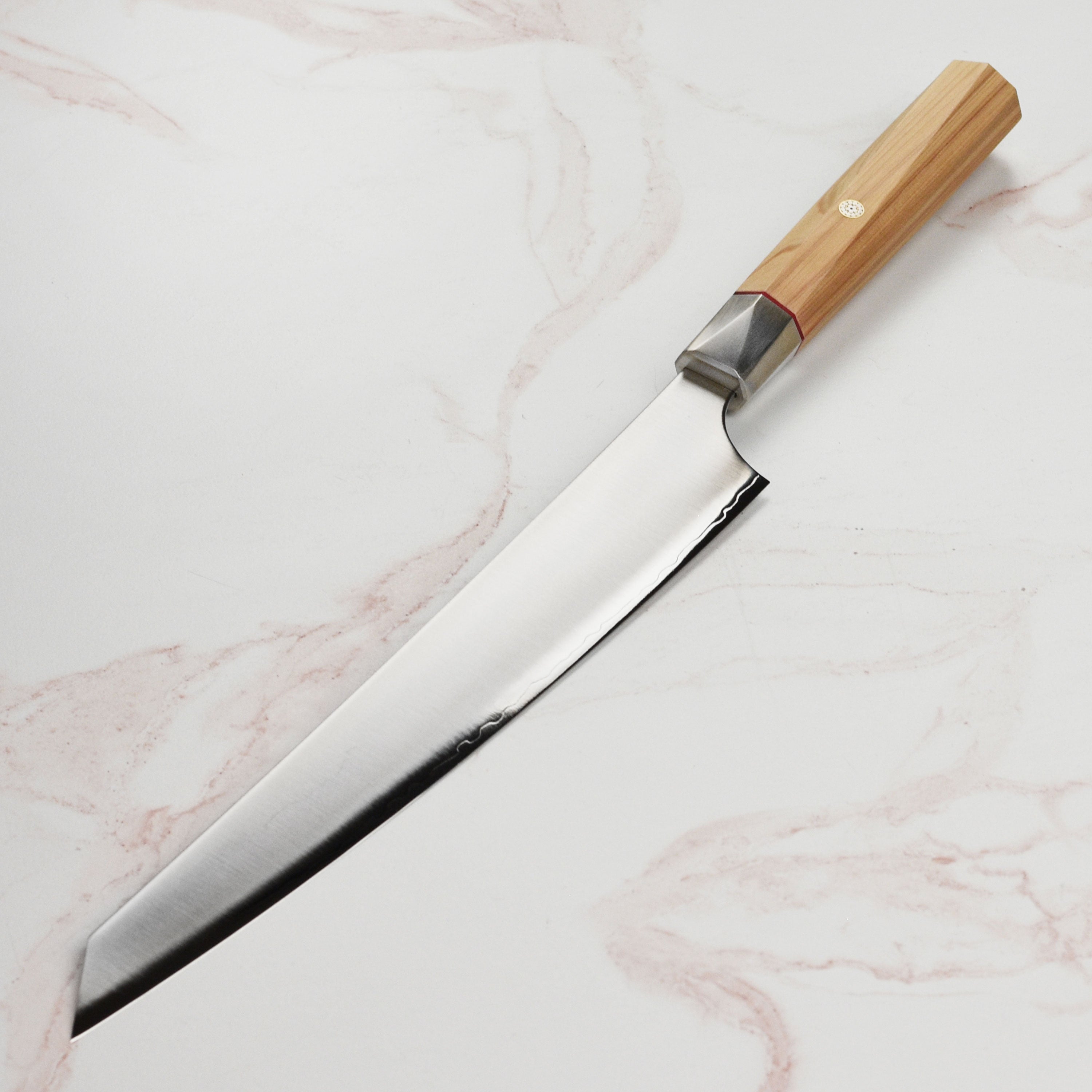 Japanese chef holding the handcrafted sujihiki for slicing meat in a professional kitchen