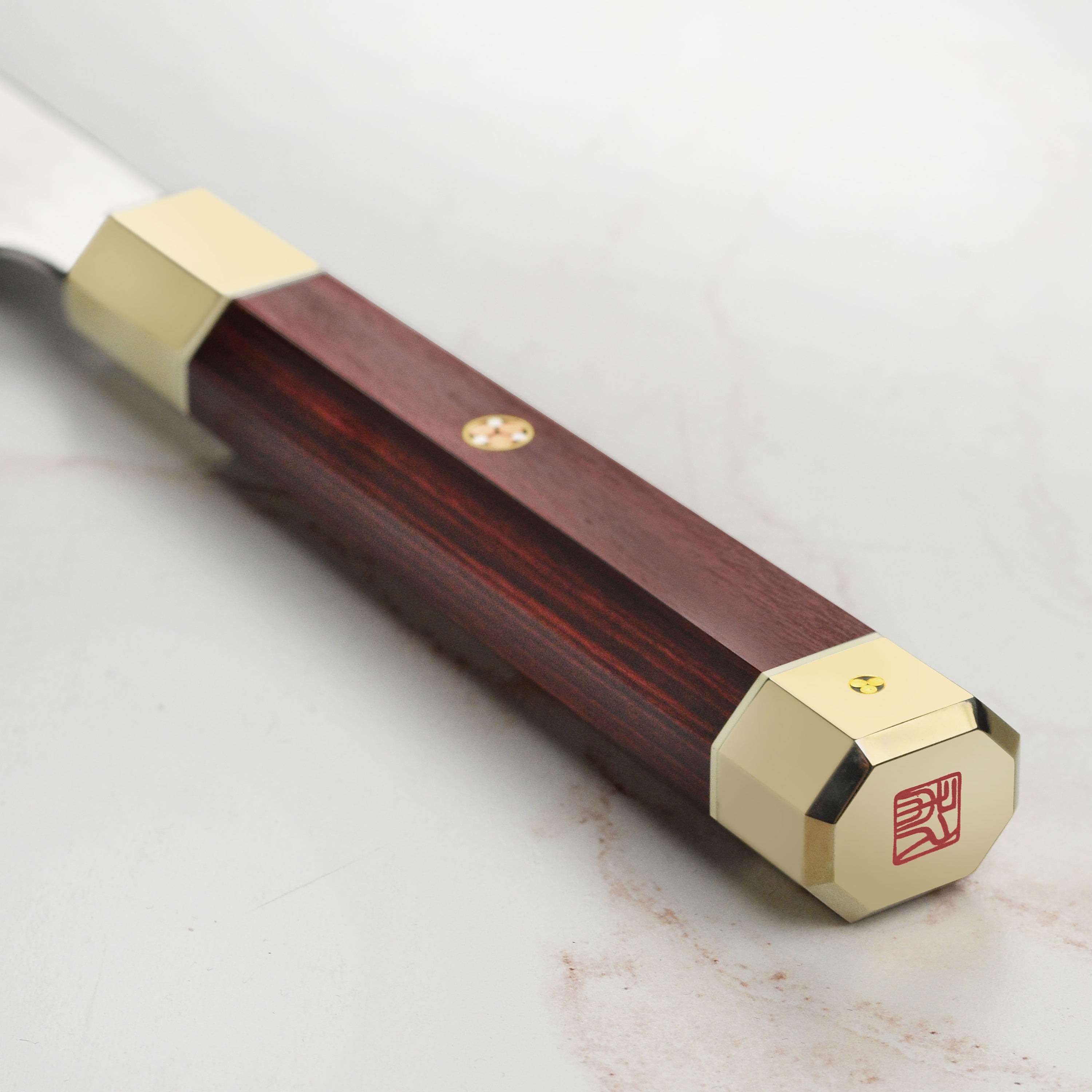 Ergonomic red Pakkawood handle of Zanmai chef knife for comfortable grip