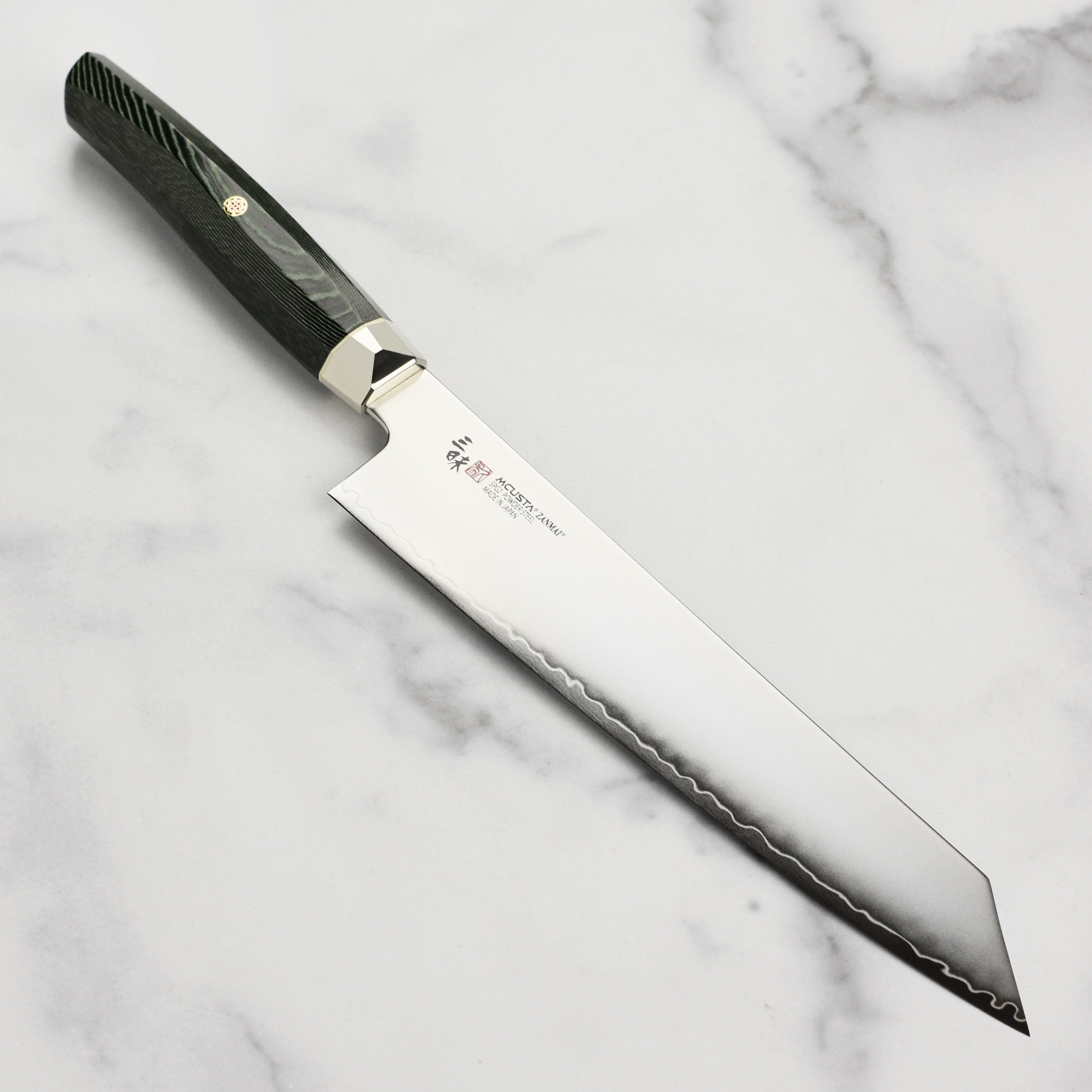 Close-up of SG2 chef knife blade with engraved logo, highlighting sharpness and 9° double bevel