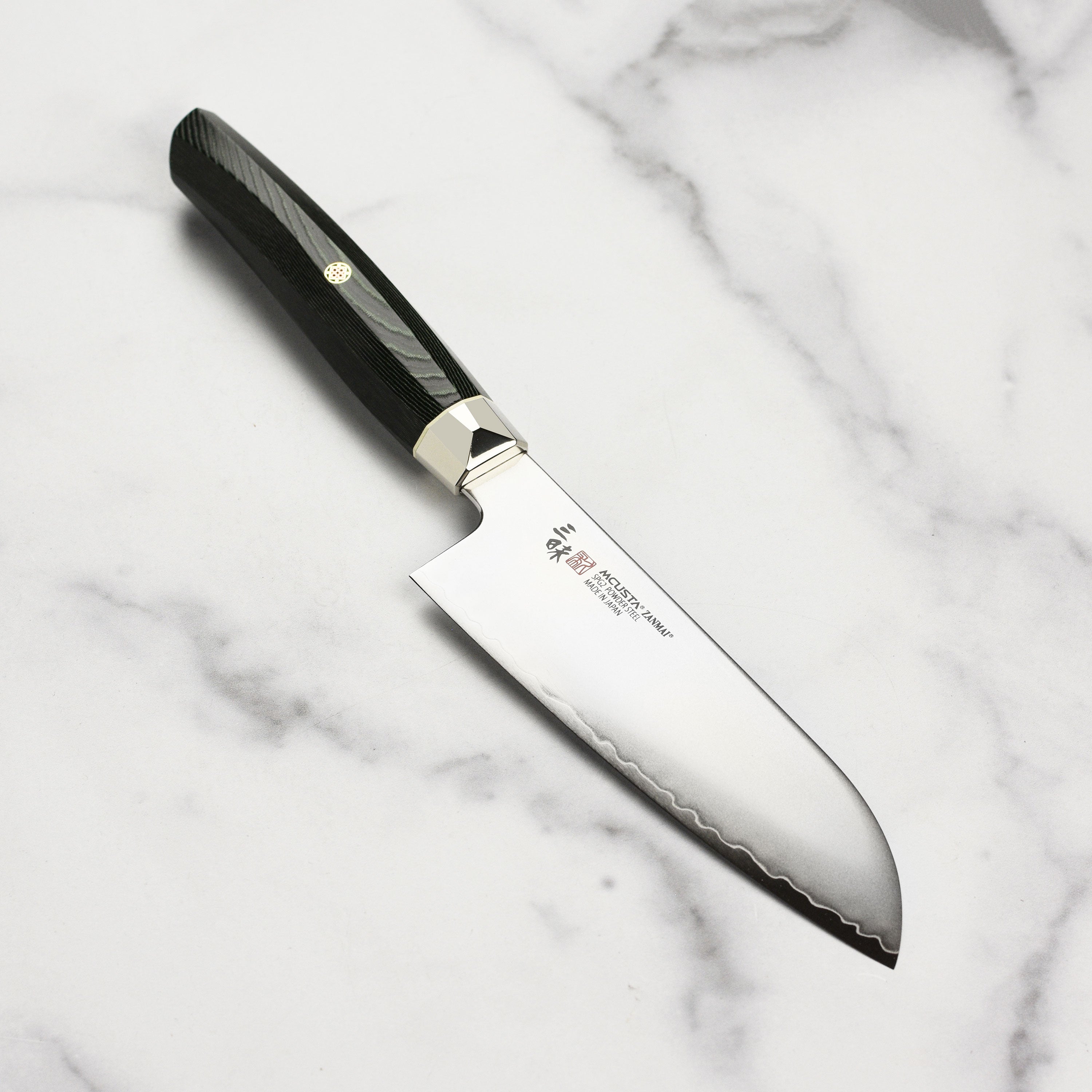 Close-up of SG2 steel blade showing fine edge and contour bolster of the Japanese kitchen knife.