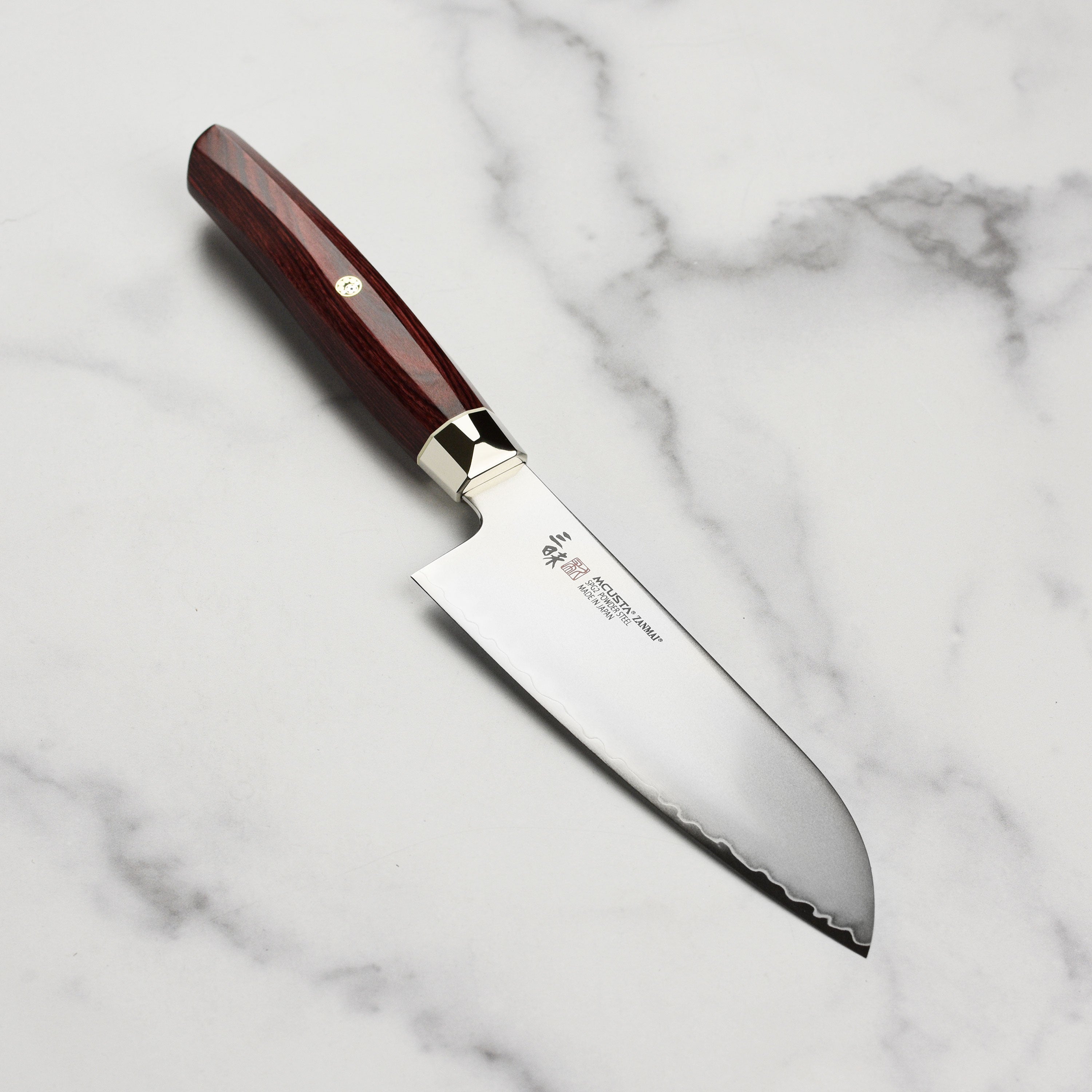Zanmai Revolution SG2 Santoku knife showcasing its sharp edge and elegant red Pakkawood handle.