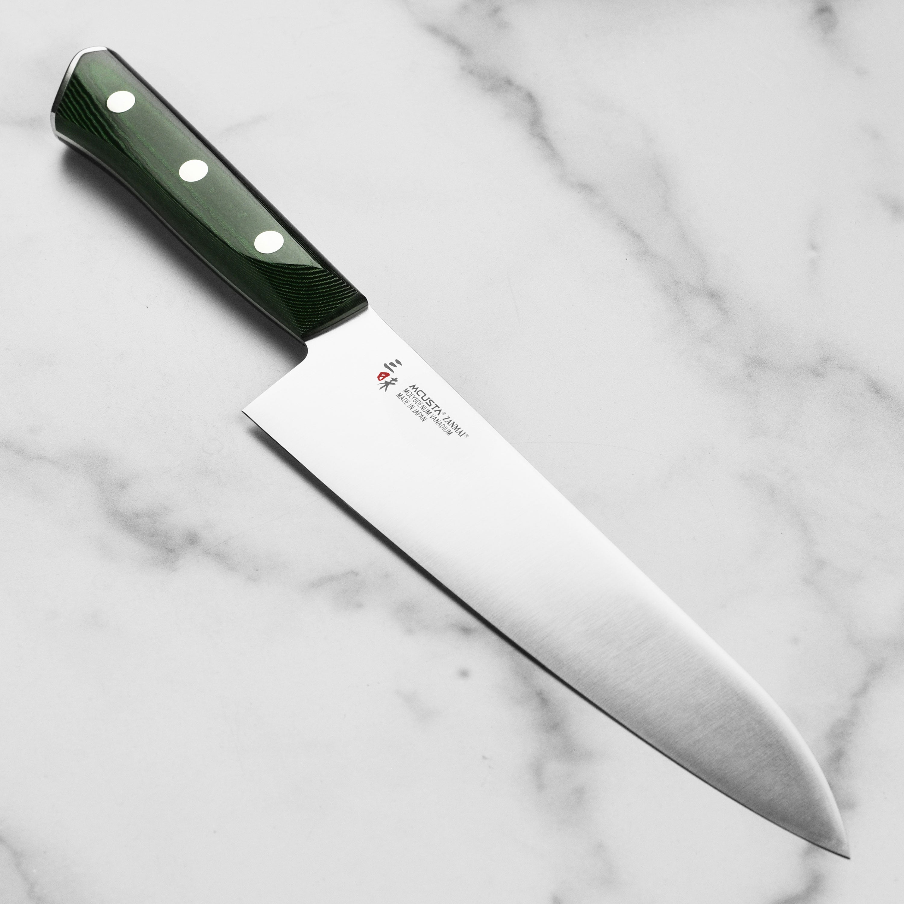 Close-up of the Zanmai Forest gyuto knife blade showing its polished finish and sharp edge.