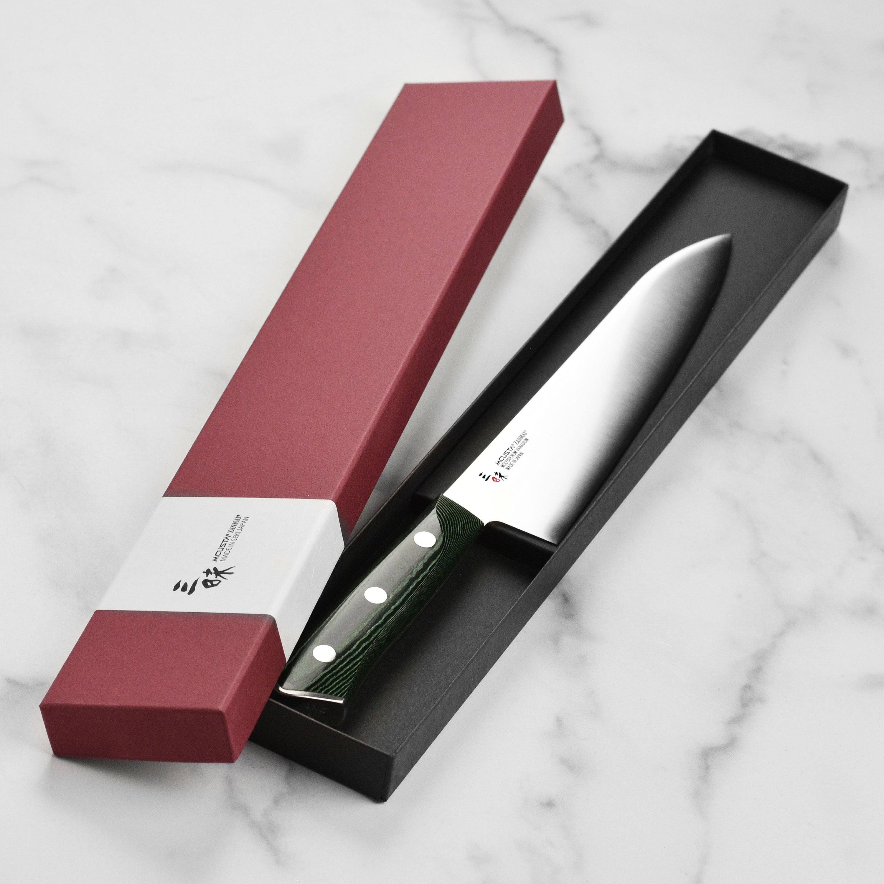 Seki City craftsmanship of the Zanmai Forest gyuto knife displayed on a wooden cutting board.
