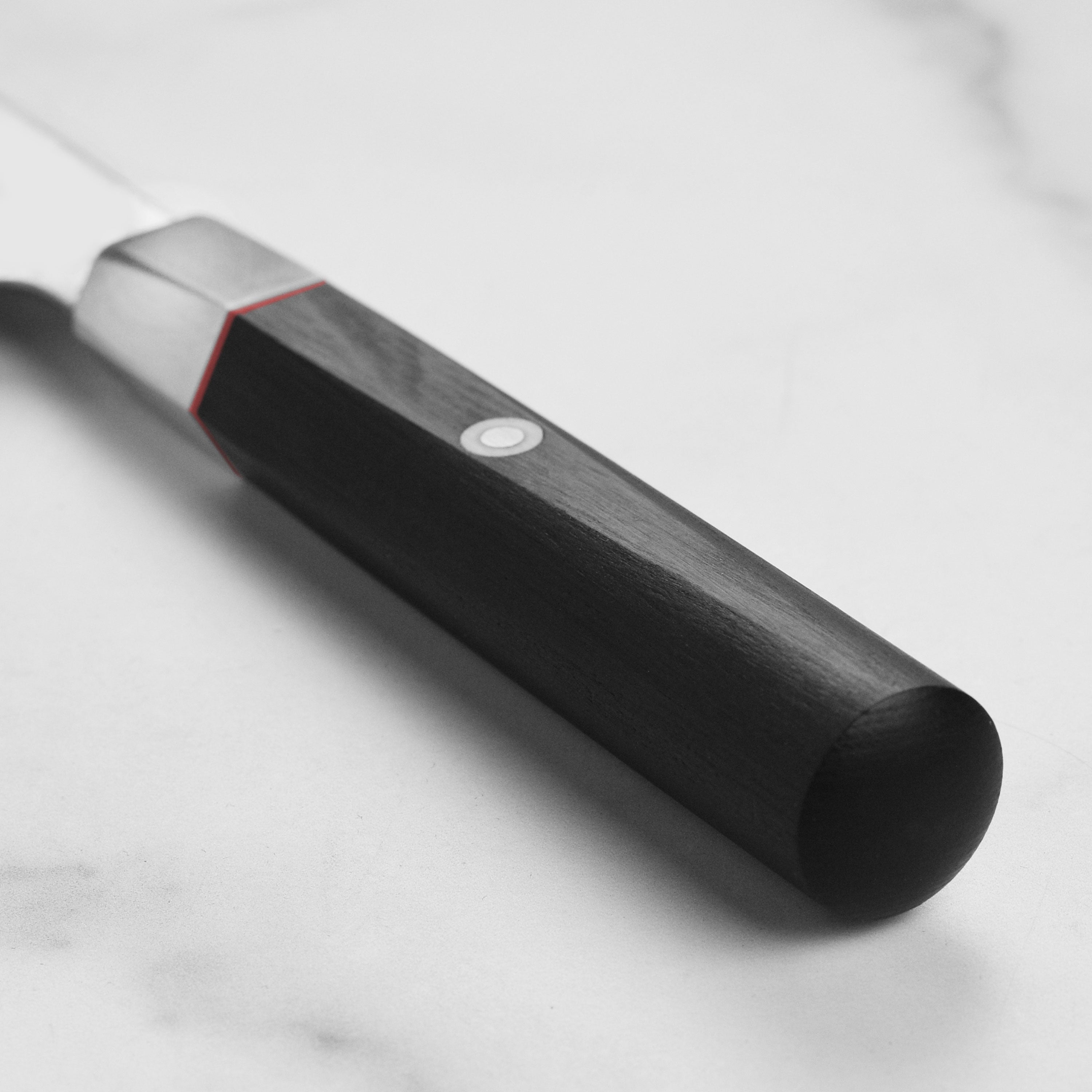 Close-up of the knifes blade showing the VG10 steel and 61 Rockwell hardness, perfect for professional chefs.