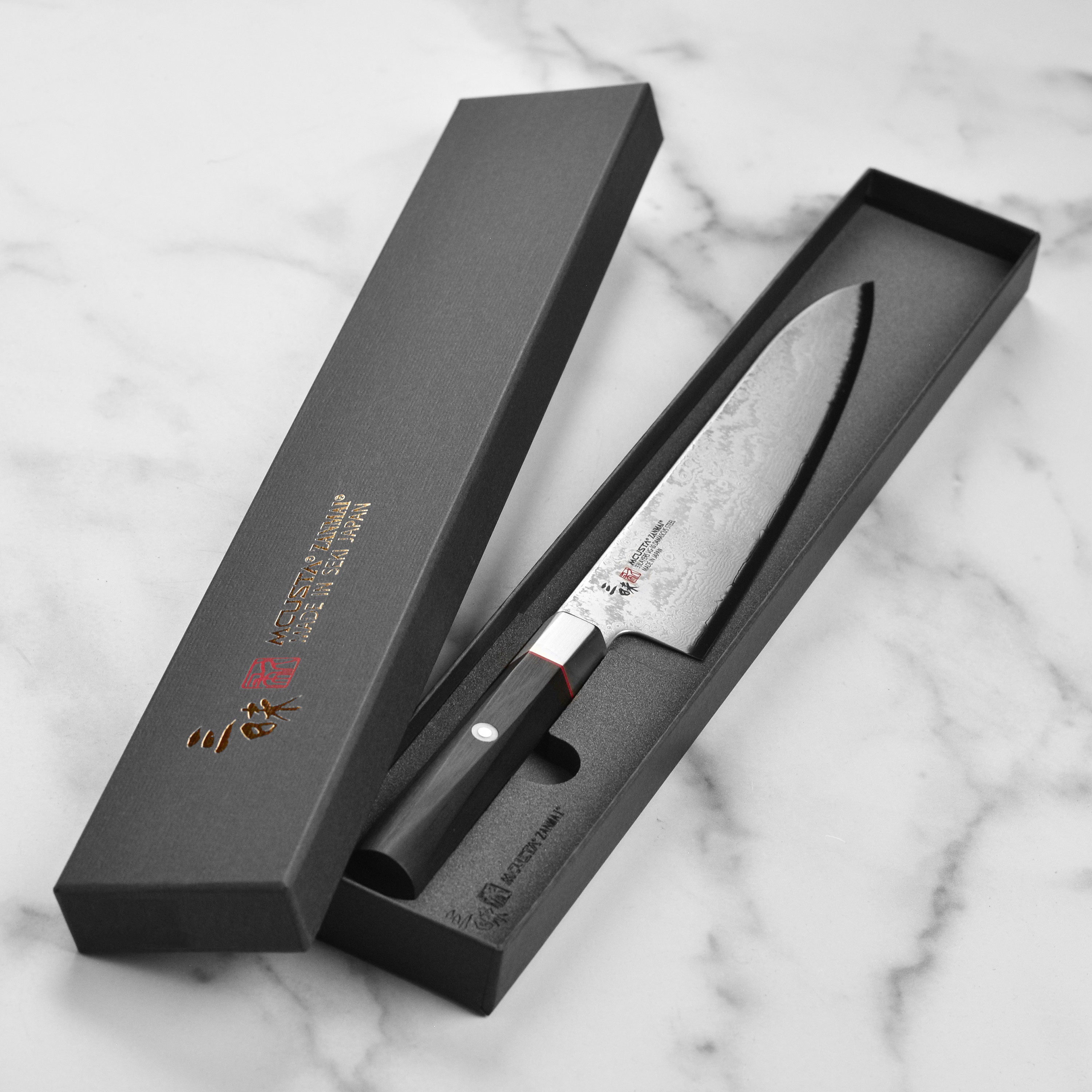 Zanmai Gyuto knife displayed in a kitchen setting, highlighting its craftsmanship and ergonomic design.