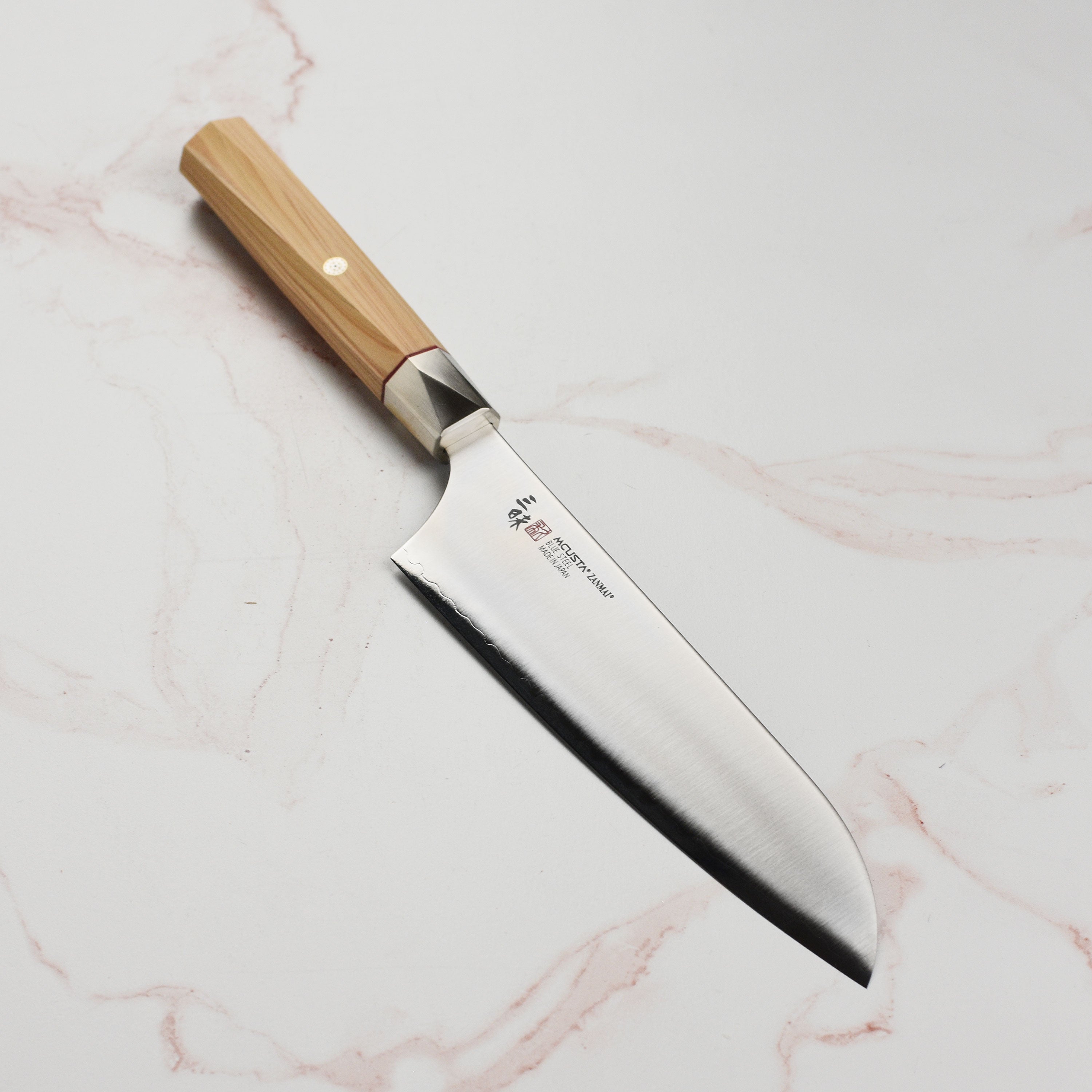 Close-up of Zanmai Beyond Aogami Super 7-inch Santoku knife showing the sharp edge and polished finish