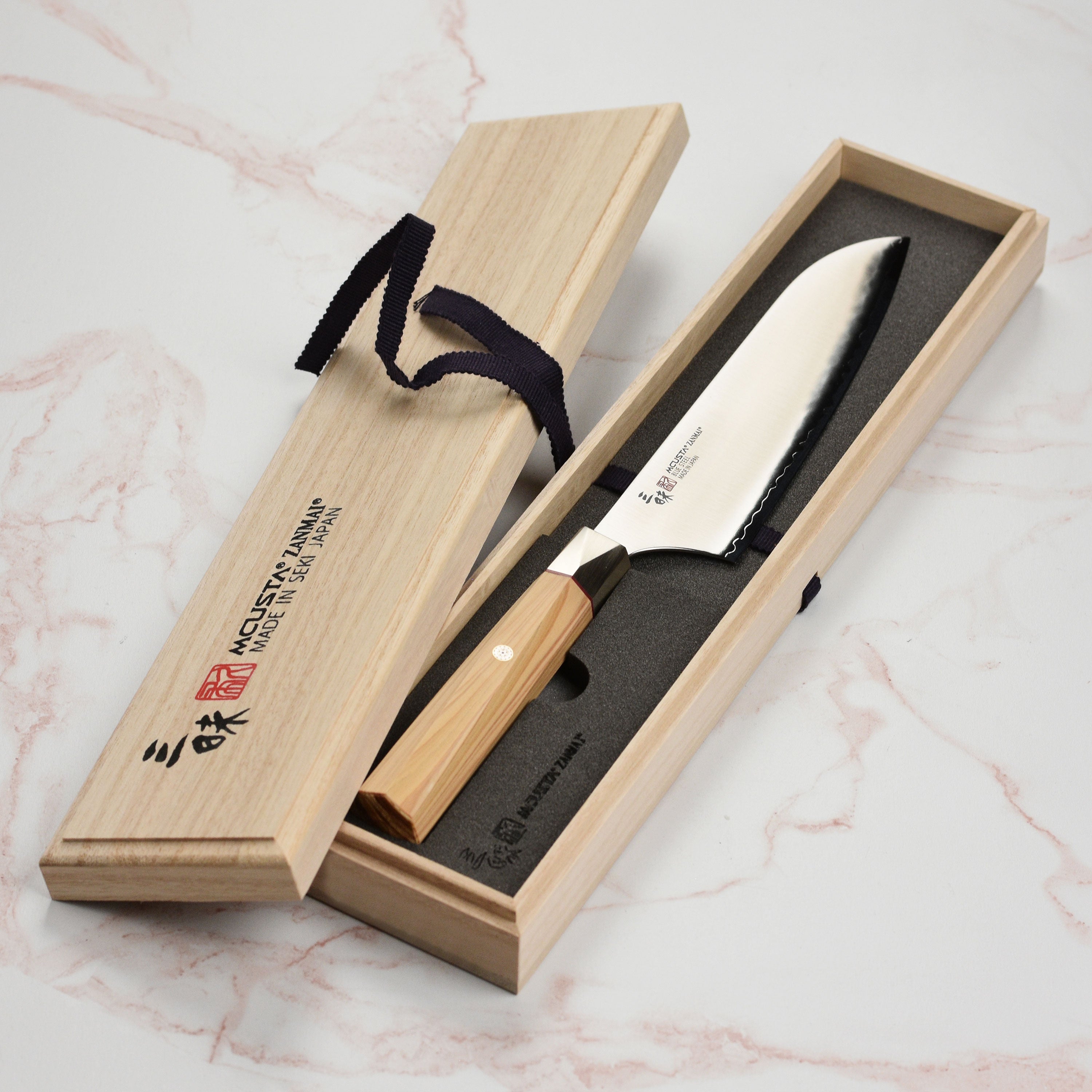 Full view of the handcrafted handle and bolster of the Zanmai Santoku knife