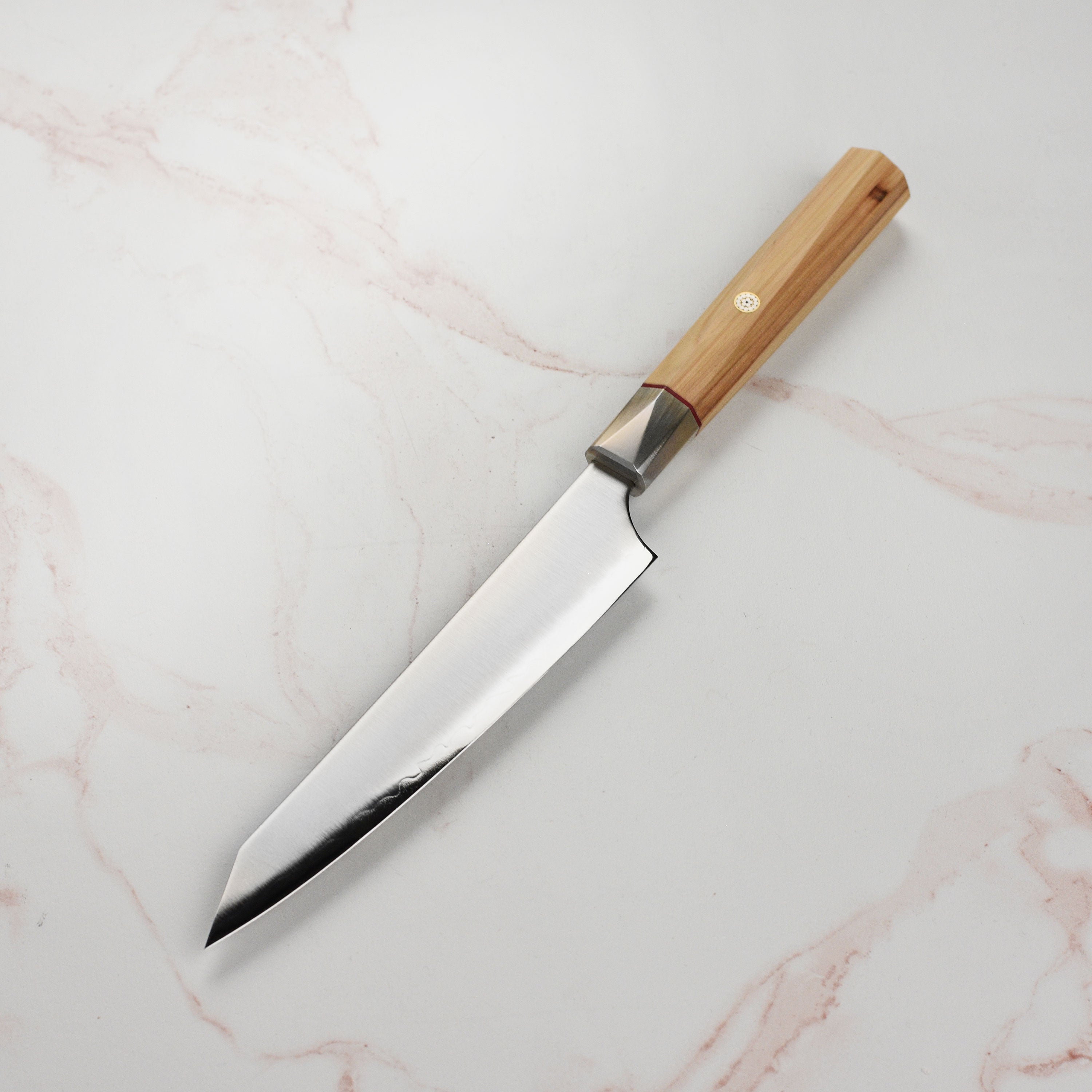 Close-up of the double bevel edge of the Zanmai paring knife, highlighting its sharpness.