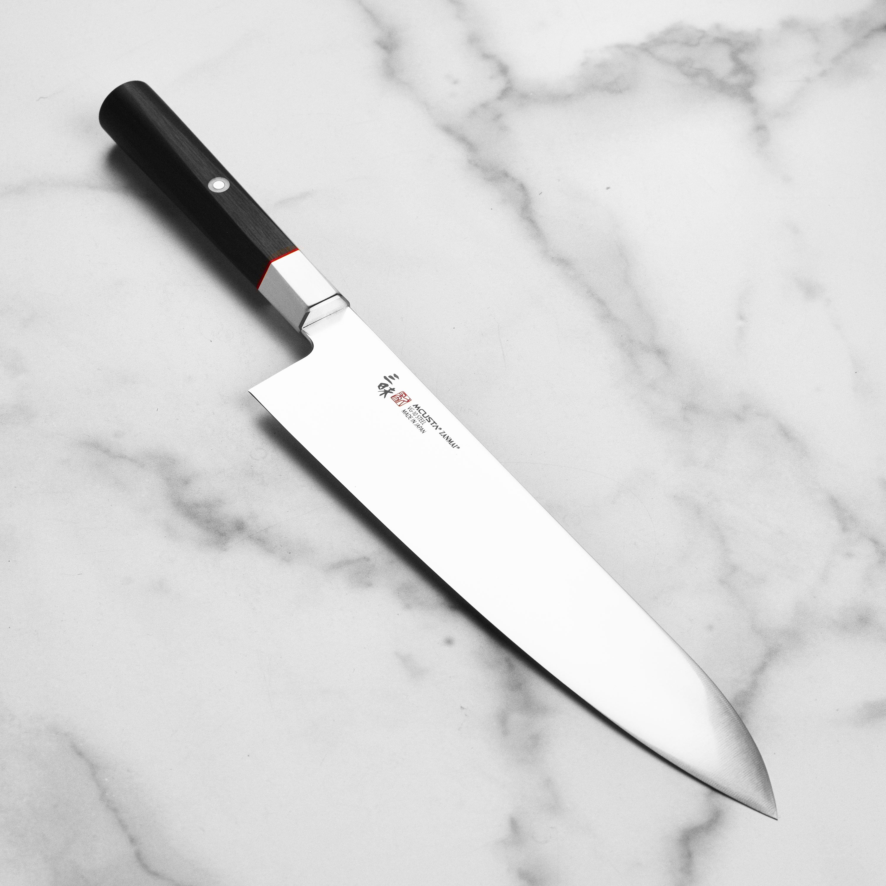 Side view of the Zanmai VG10 Gyuto knife highlighting its sharp blade and elegant Pakkawood handle.