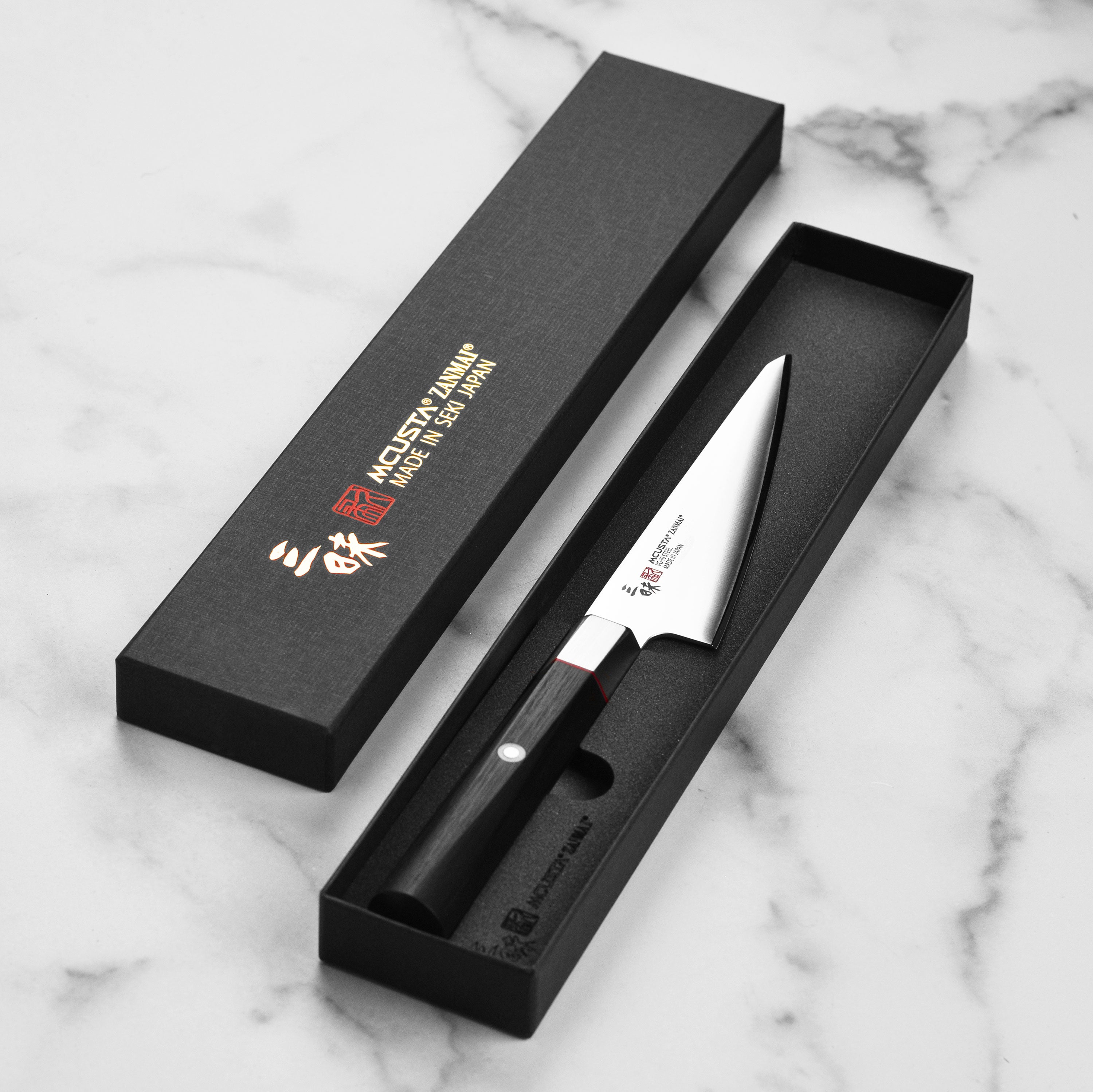 Elegant presentation of the Seki City Premium VG10 Honesuki Knife with a cutting board and fresh ingredients.