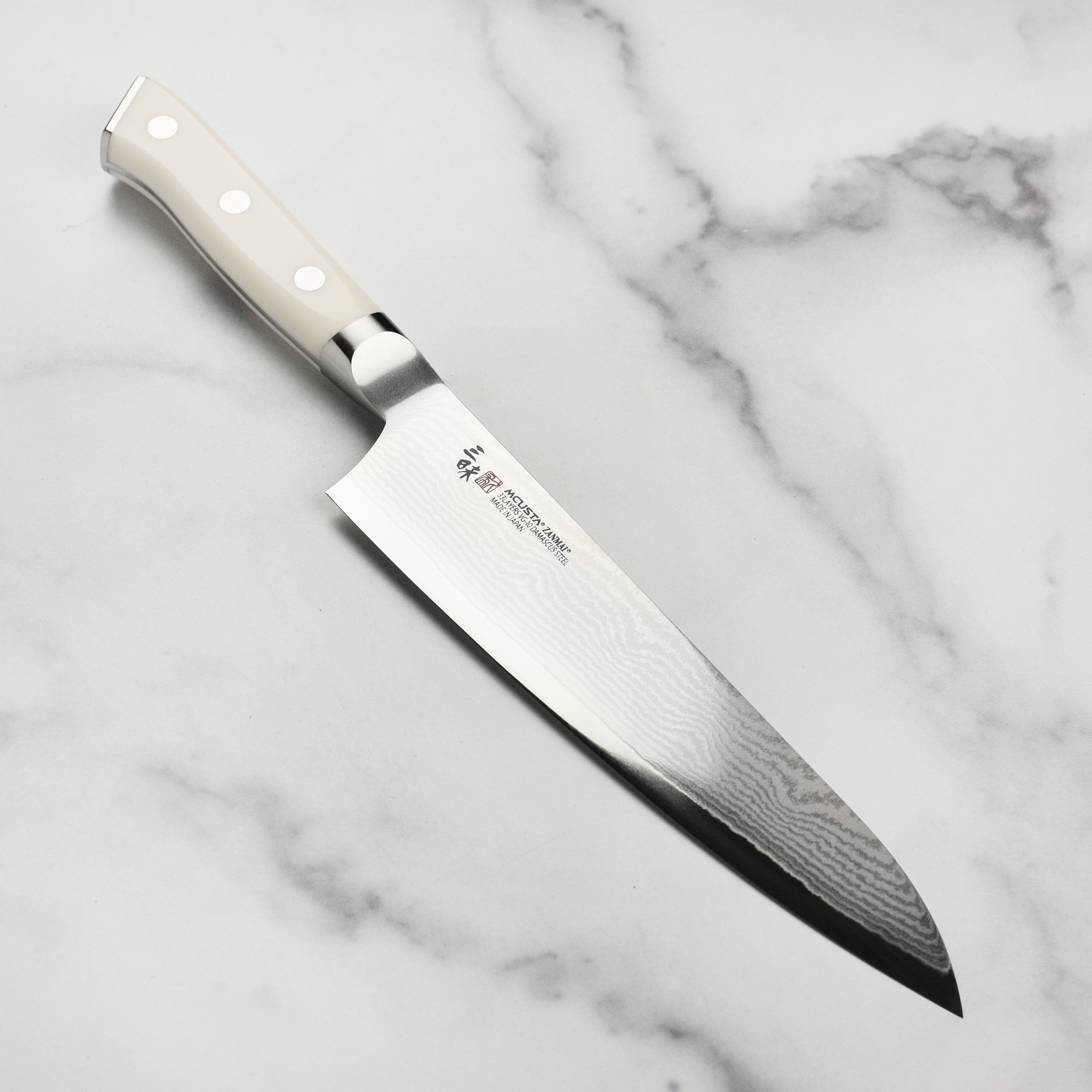 Close-up of Zanmai Damascus gyuto knife blade showing Damascus pattern