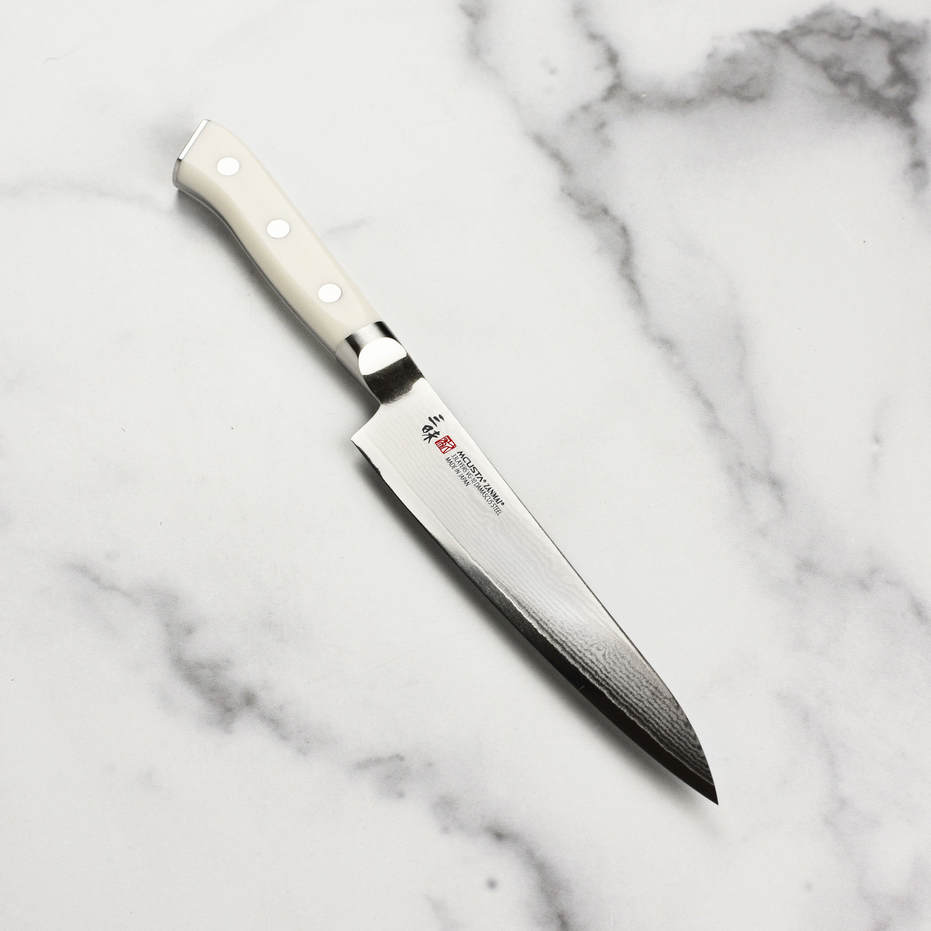 Detailed view of the damascus stainless steel blade on Zanmai Classic Petty Knife, highlighting craftsmanship.