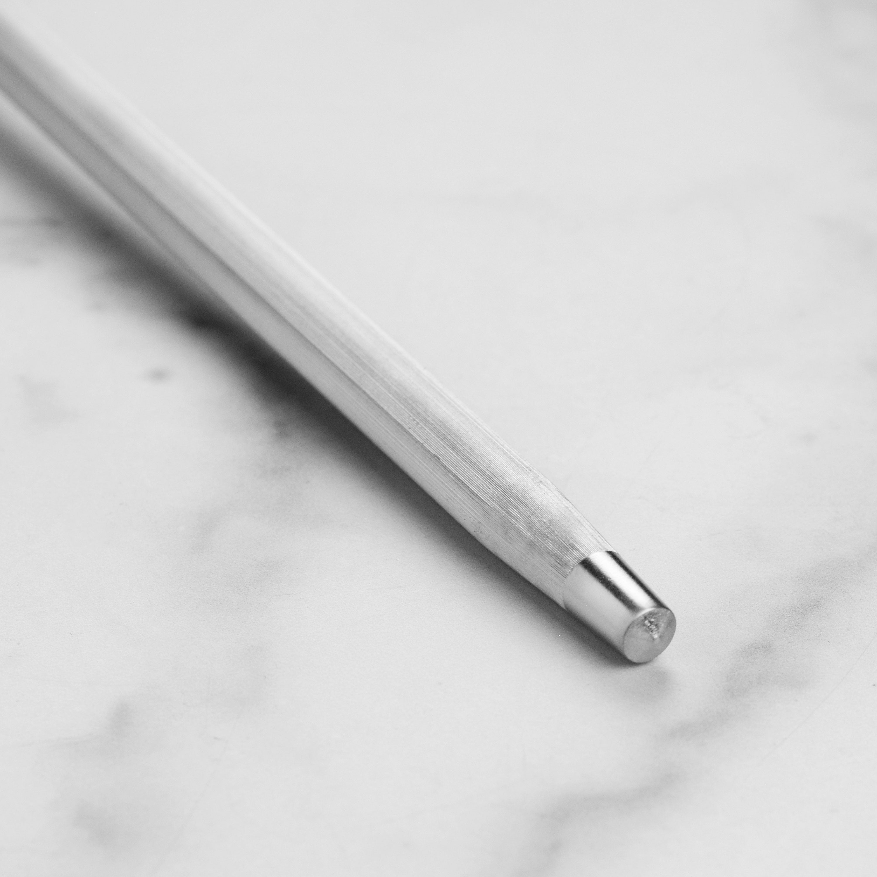 Enso honing steel displayed on a wooden cutting board alongside chef knives.
