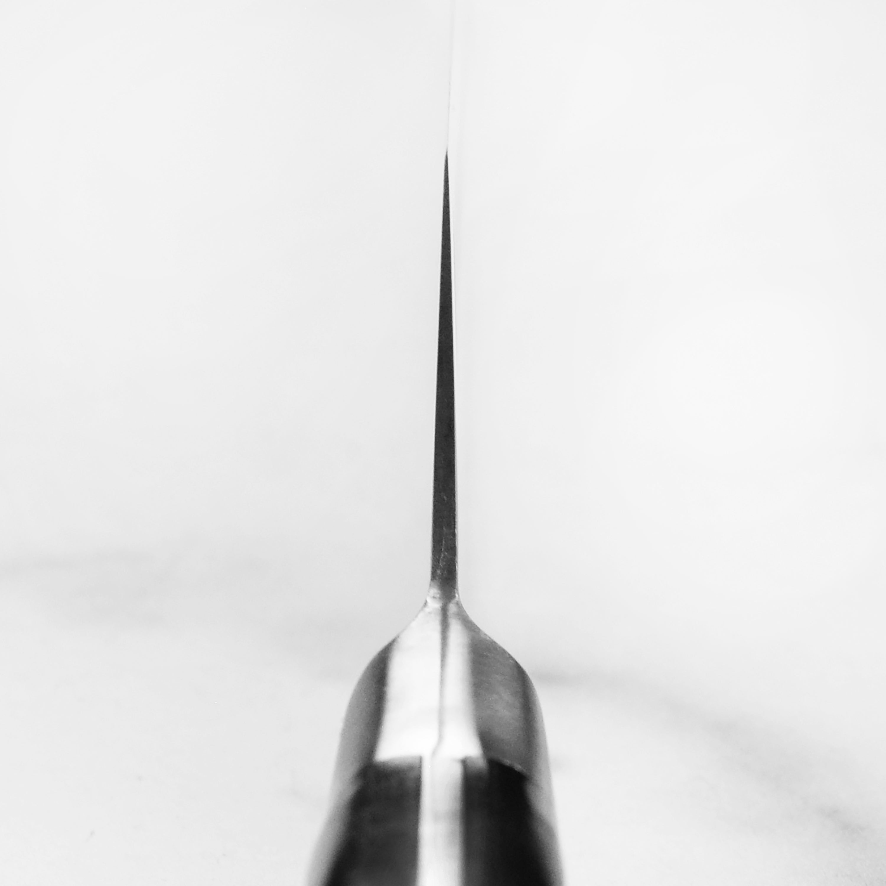 Close-up of MAC Japanese chef knife with hollow edge blade slicing vegetables