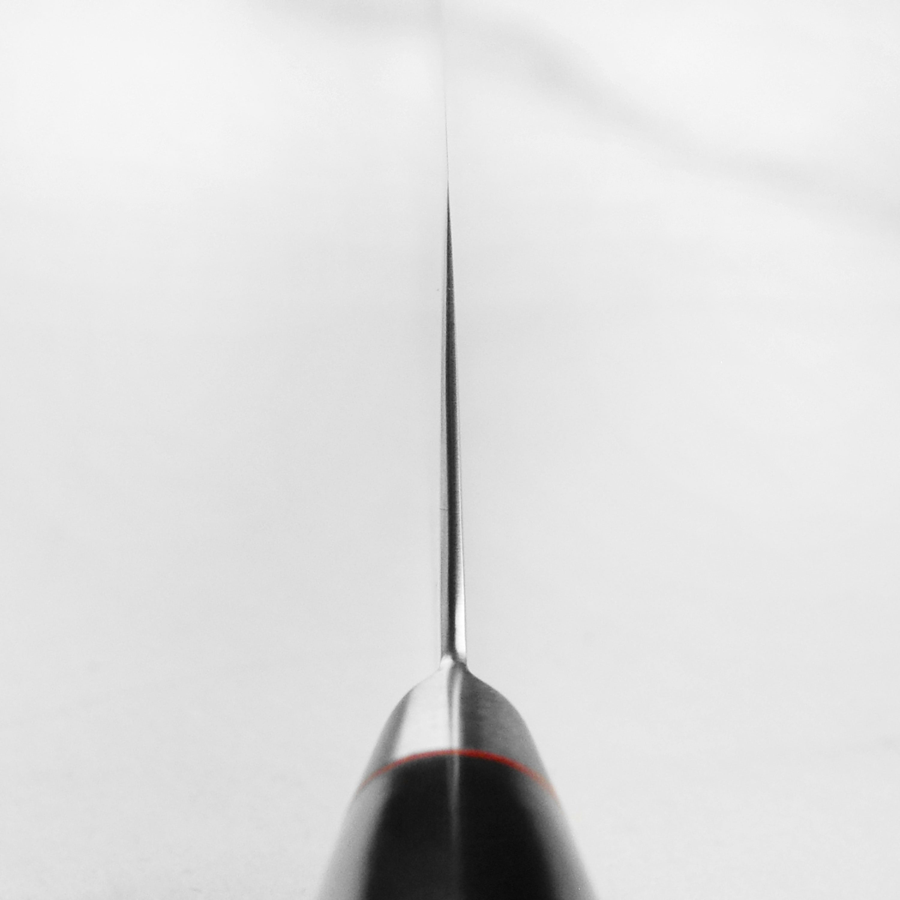 Close-up of Damascus nakiri knife blade showing 33-layer steel pattern and VG10 core