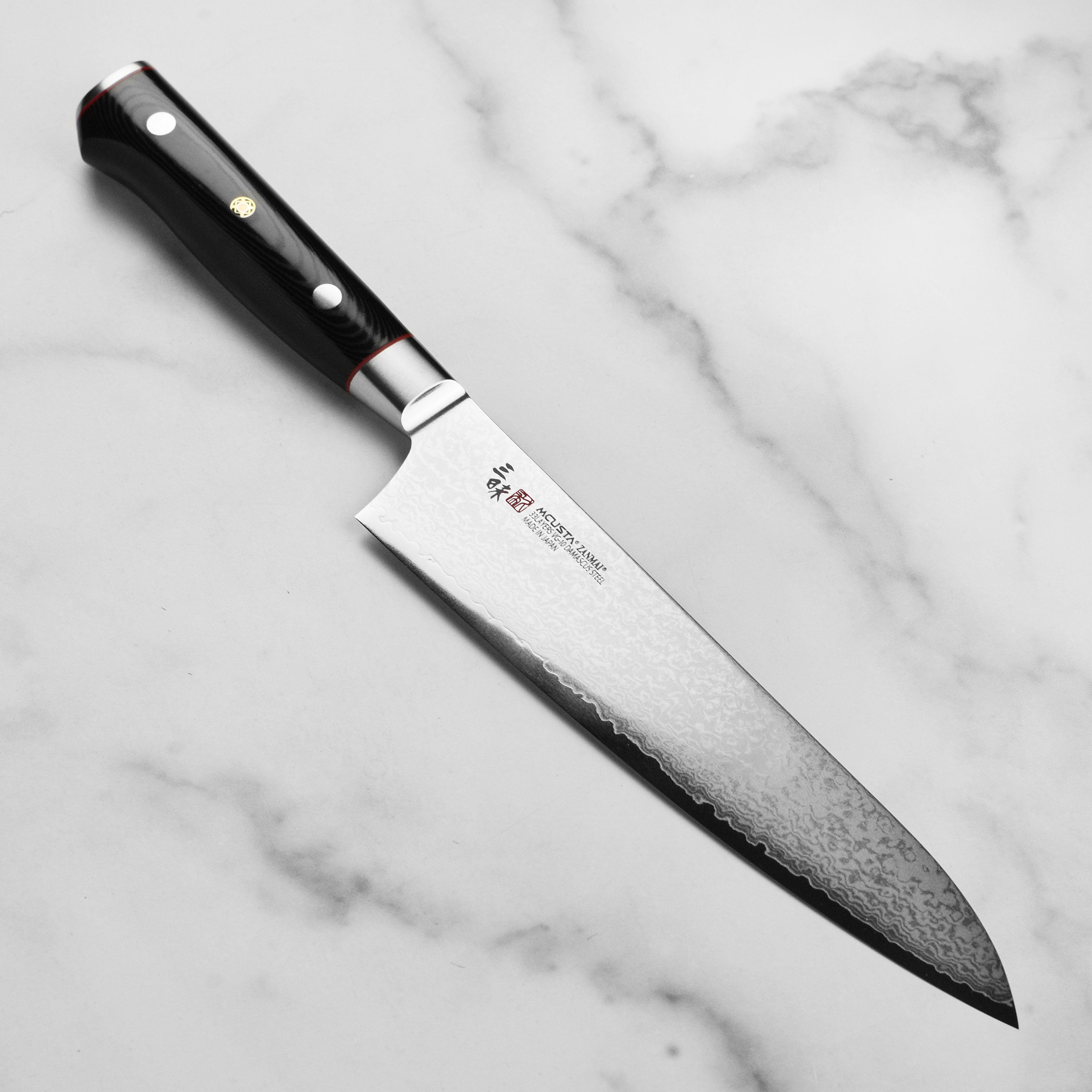 Zanmai Damascus Gyuto chef knife with layered steel blade and ergonomic handle for precision cutting