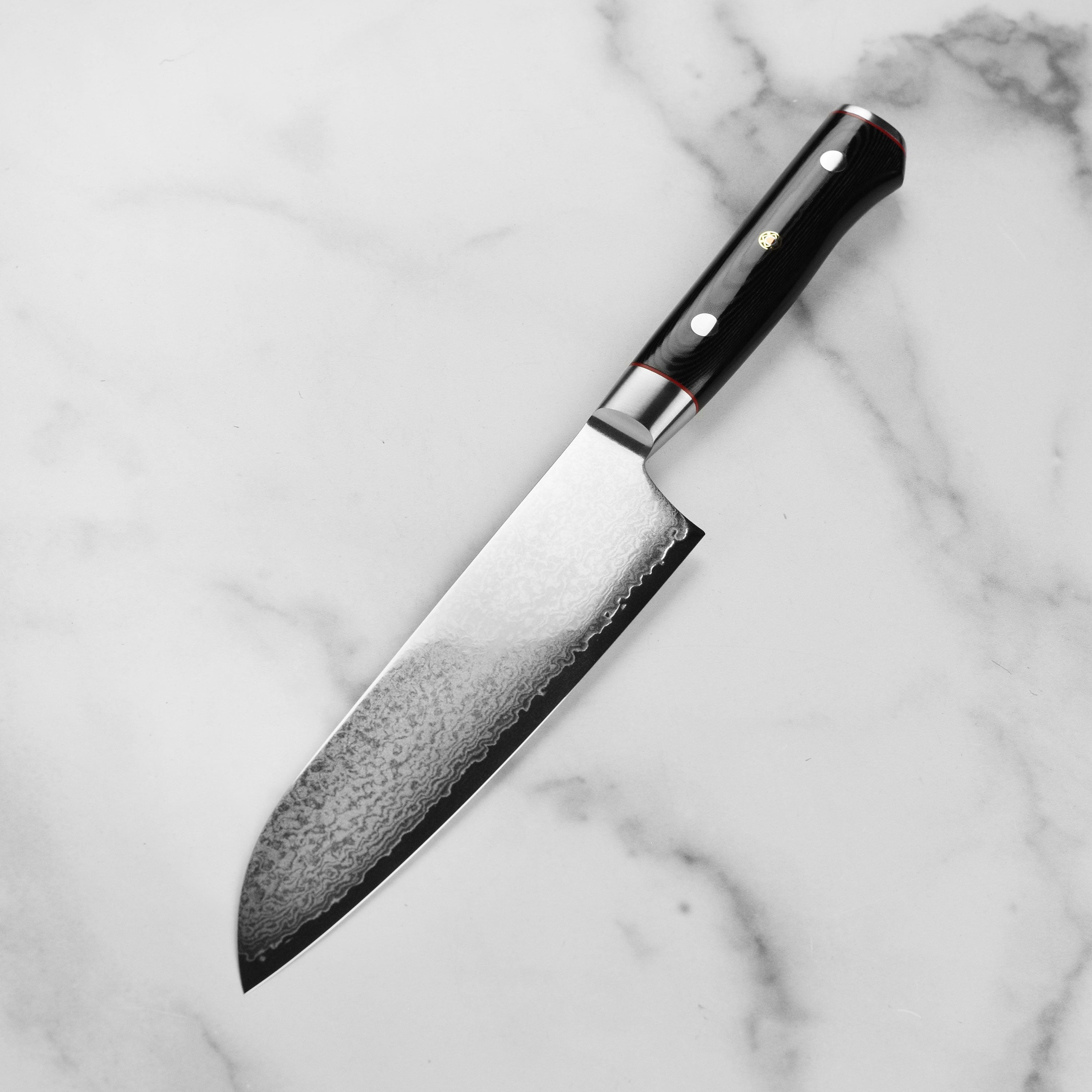 Close-up of the VG10 core of the Zanmai Santoku knife highlighting its sharp double bevel edge.