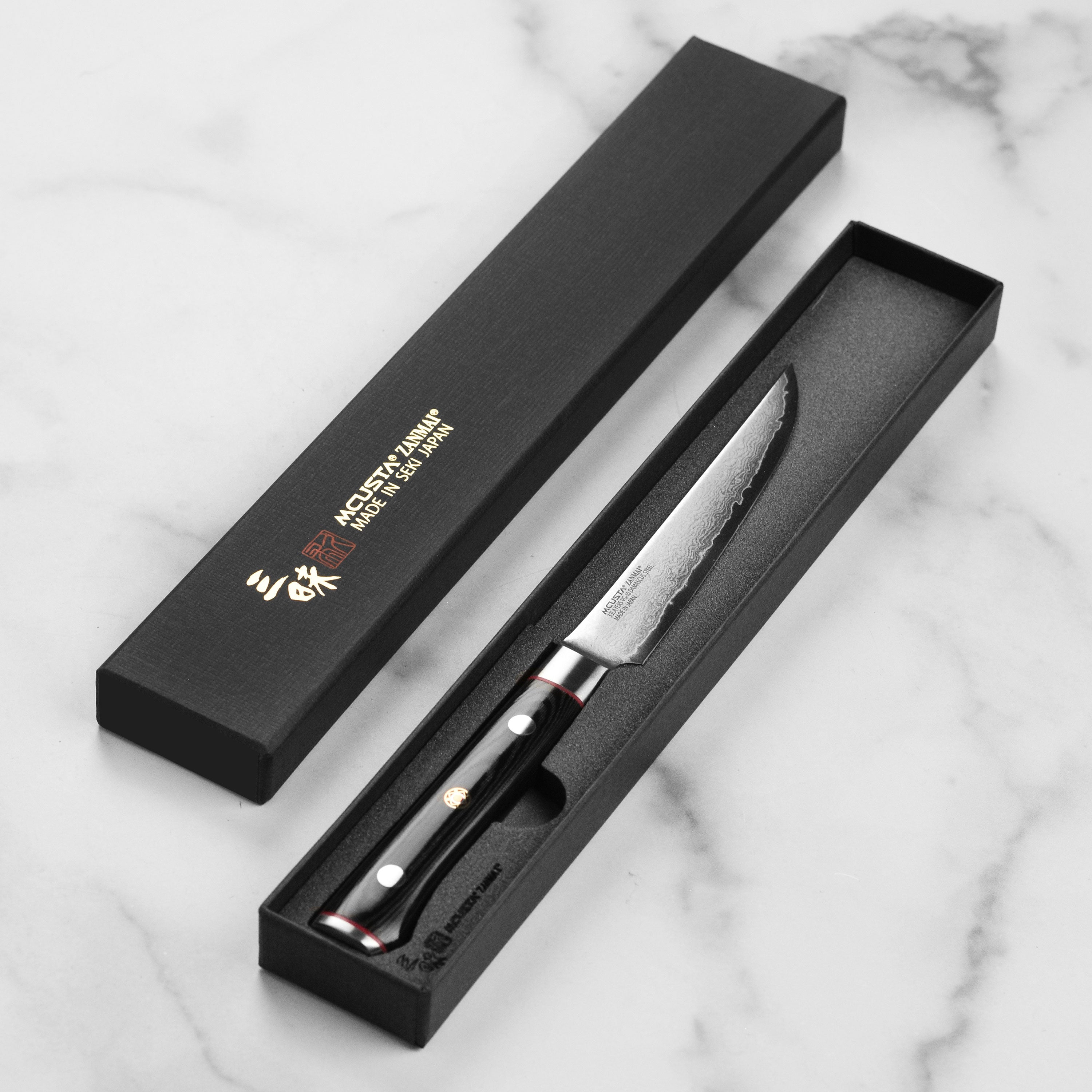The Zanmai Classic Pro Zebra steak knife in use, cutting through a perfectly cooked steak, demonstrating its sharpness.