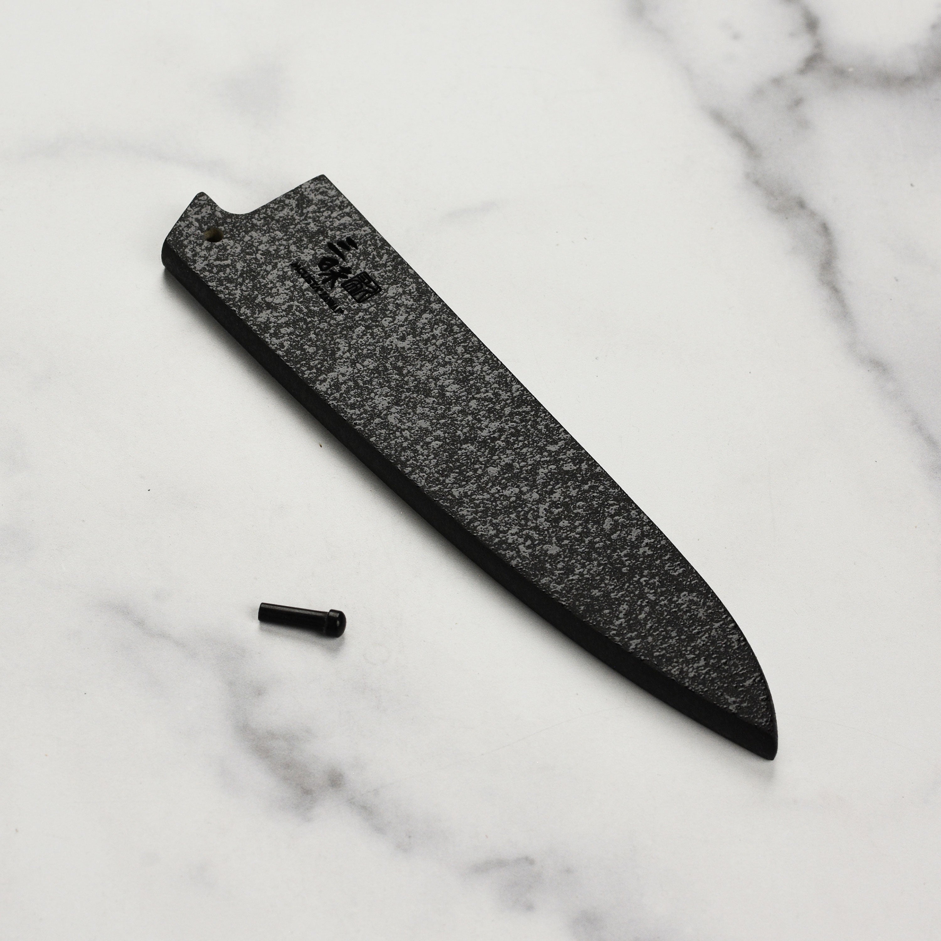Elegant black lacquer knife sheath showcasing the engraved logo and locking mechanism.