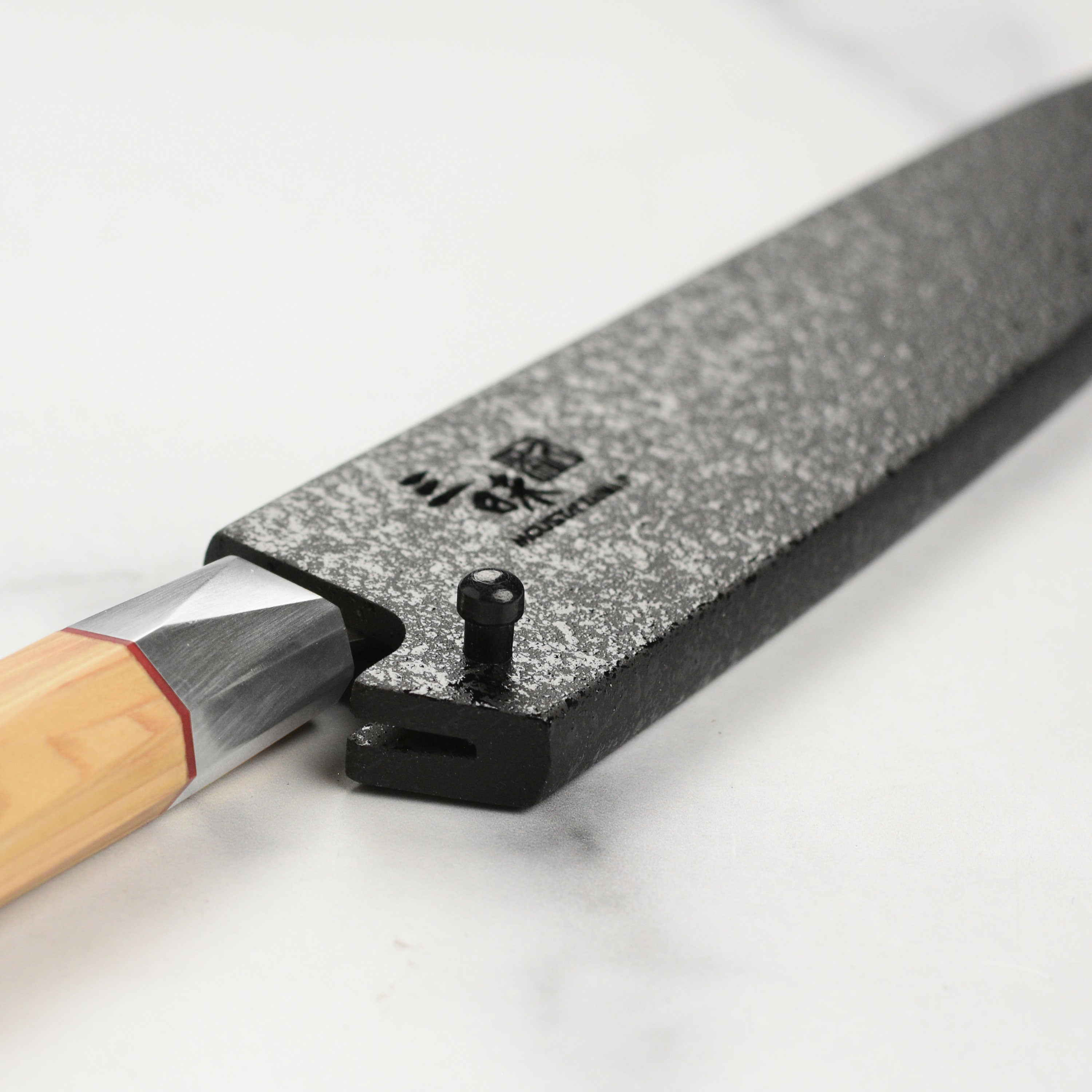 Close-up of the black mosaic pattern on the secure locking knife sheath for chefs.