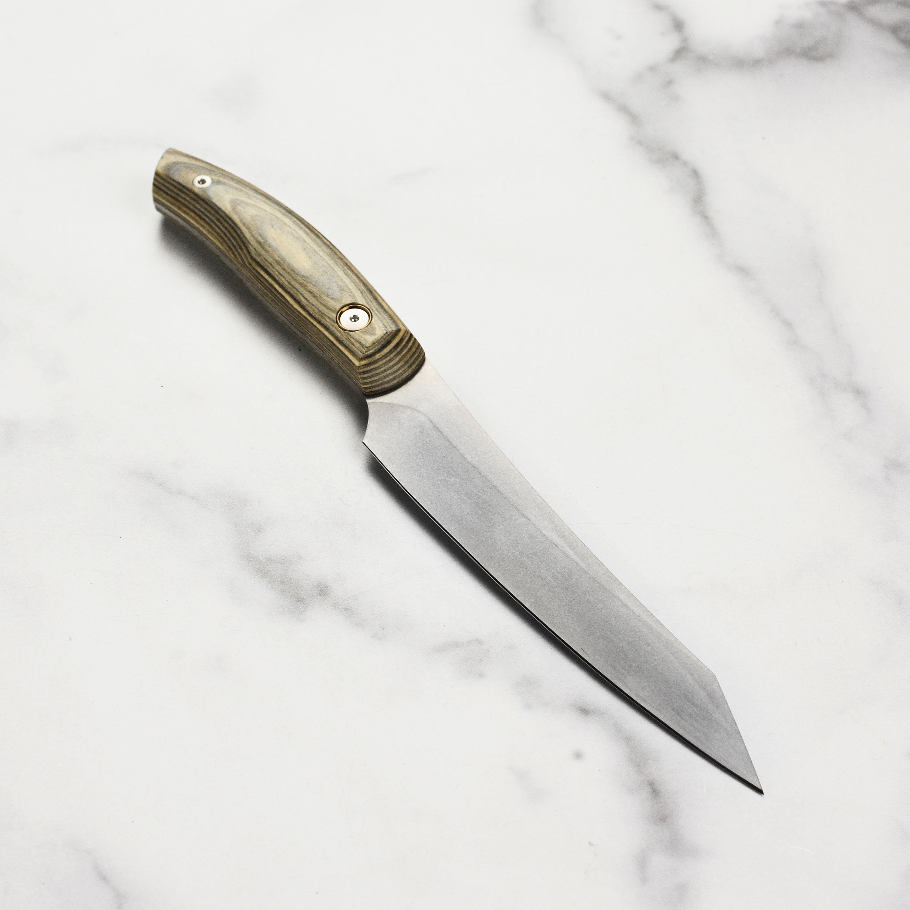 Messermeister Artisan Carbon Utility Knife in action, slicing through fresh vegetables effortlessly.