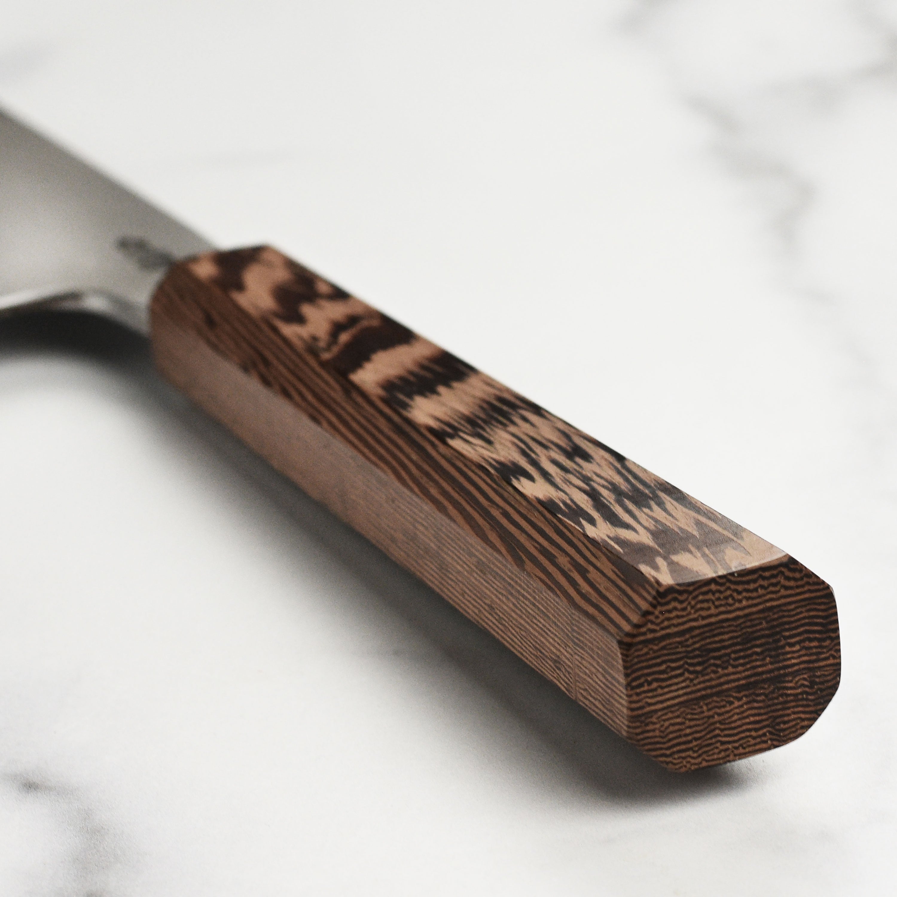 Chef using the Shirogami gyuto knife for slicing vegetables, demonstrating its versatility in the kitchen.