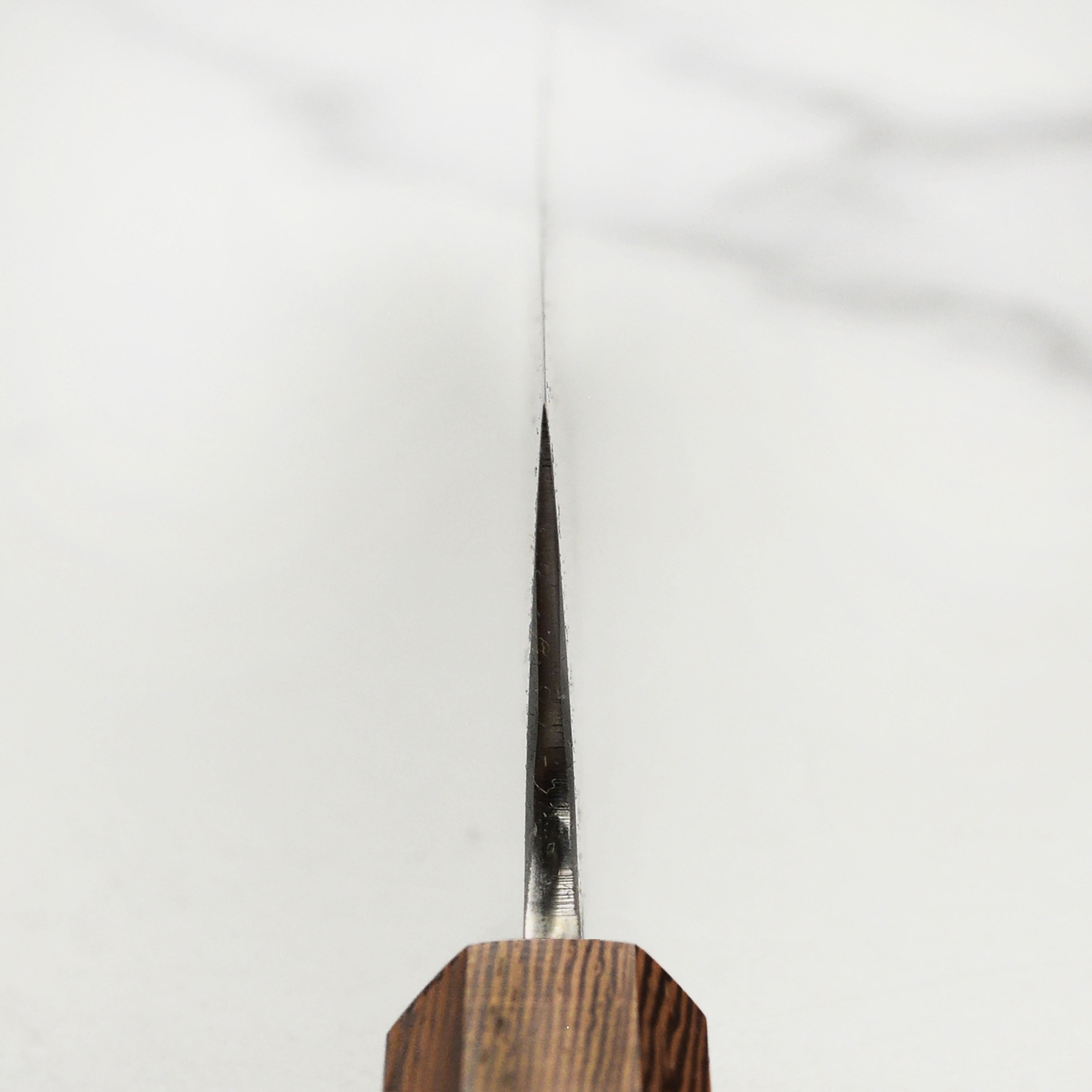 Beautiful presentation of the hand-forged gyuto knife on a wooden cutting board, showcasing its design and quality.