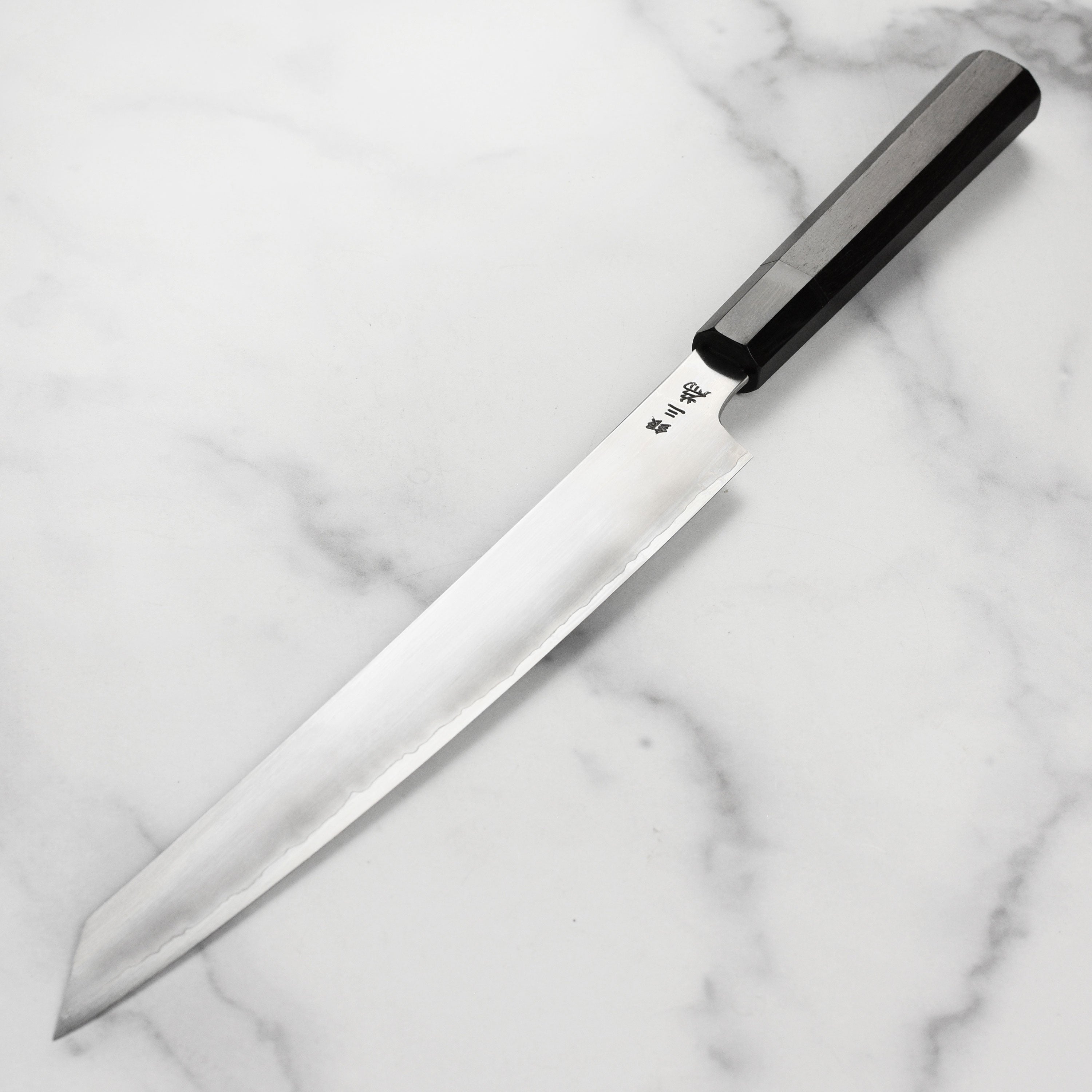 Elegant ebony handle of the Takayuki Yanagiba knife with buffalo horn ferrule
