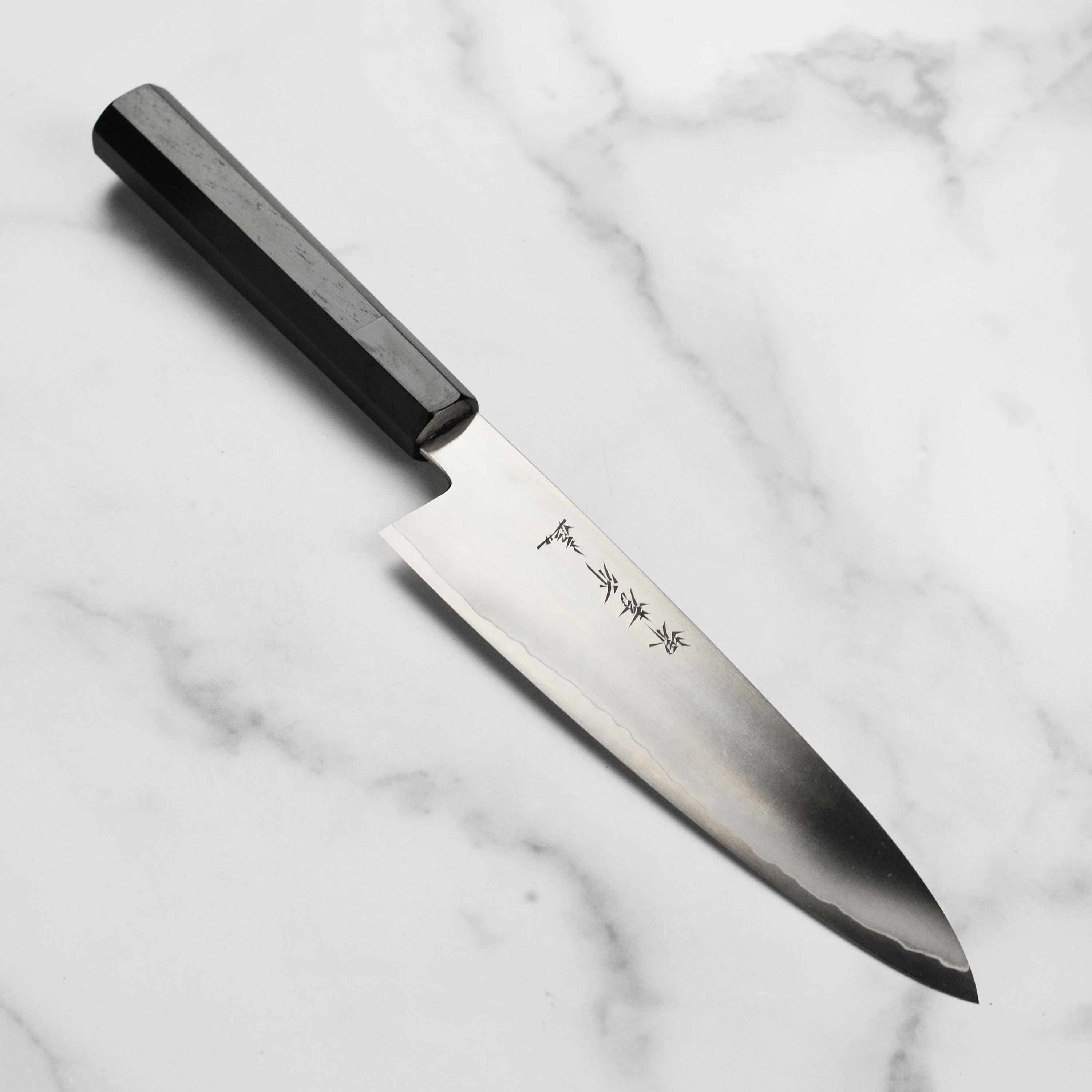 Takayuki Ginsan gyuto knife showing the elegant handle and blade angle.