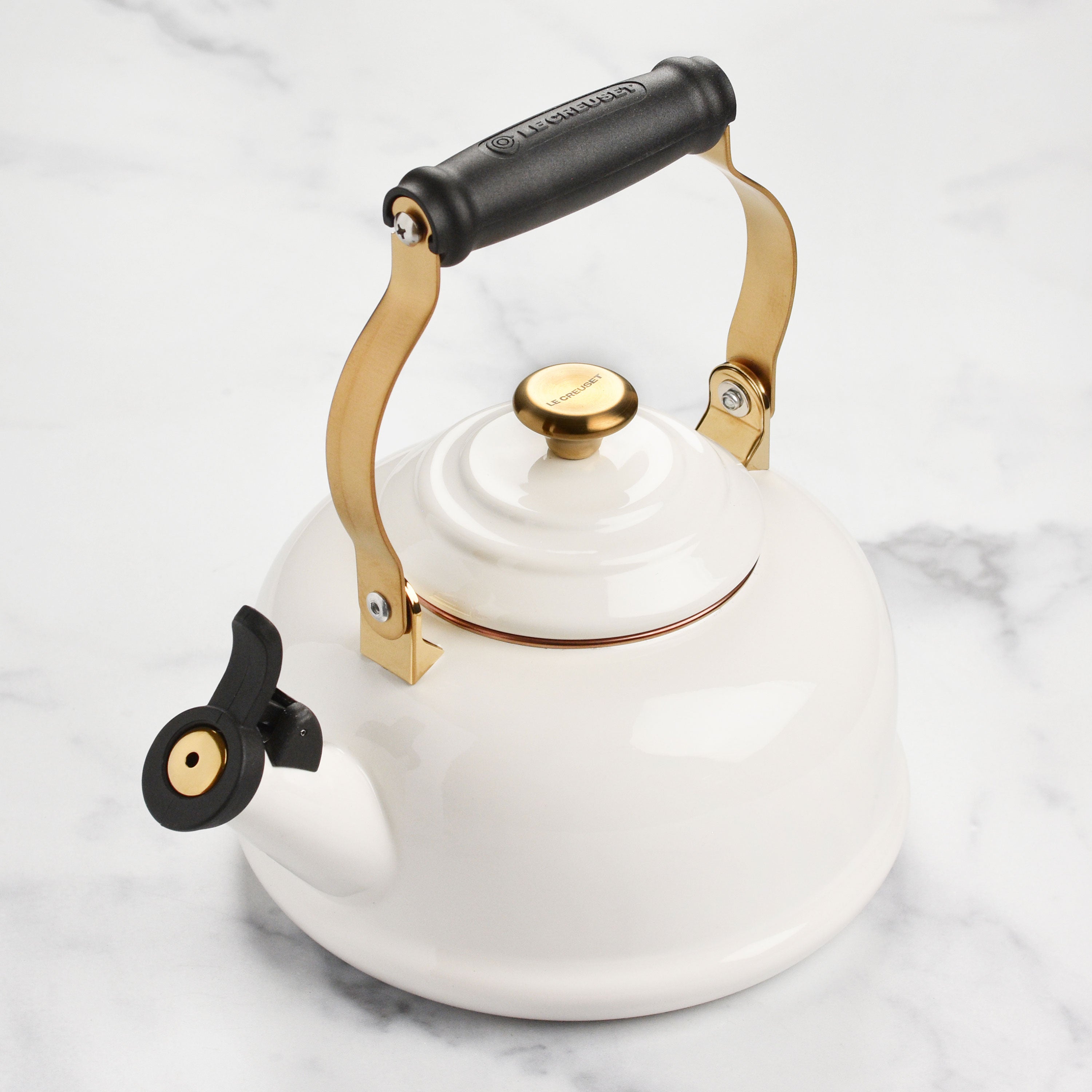Le Creuset kettle on a stovetop, demonstrating compatibility with all cooktops.