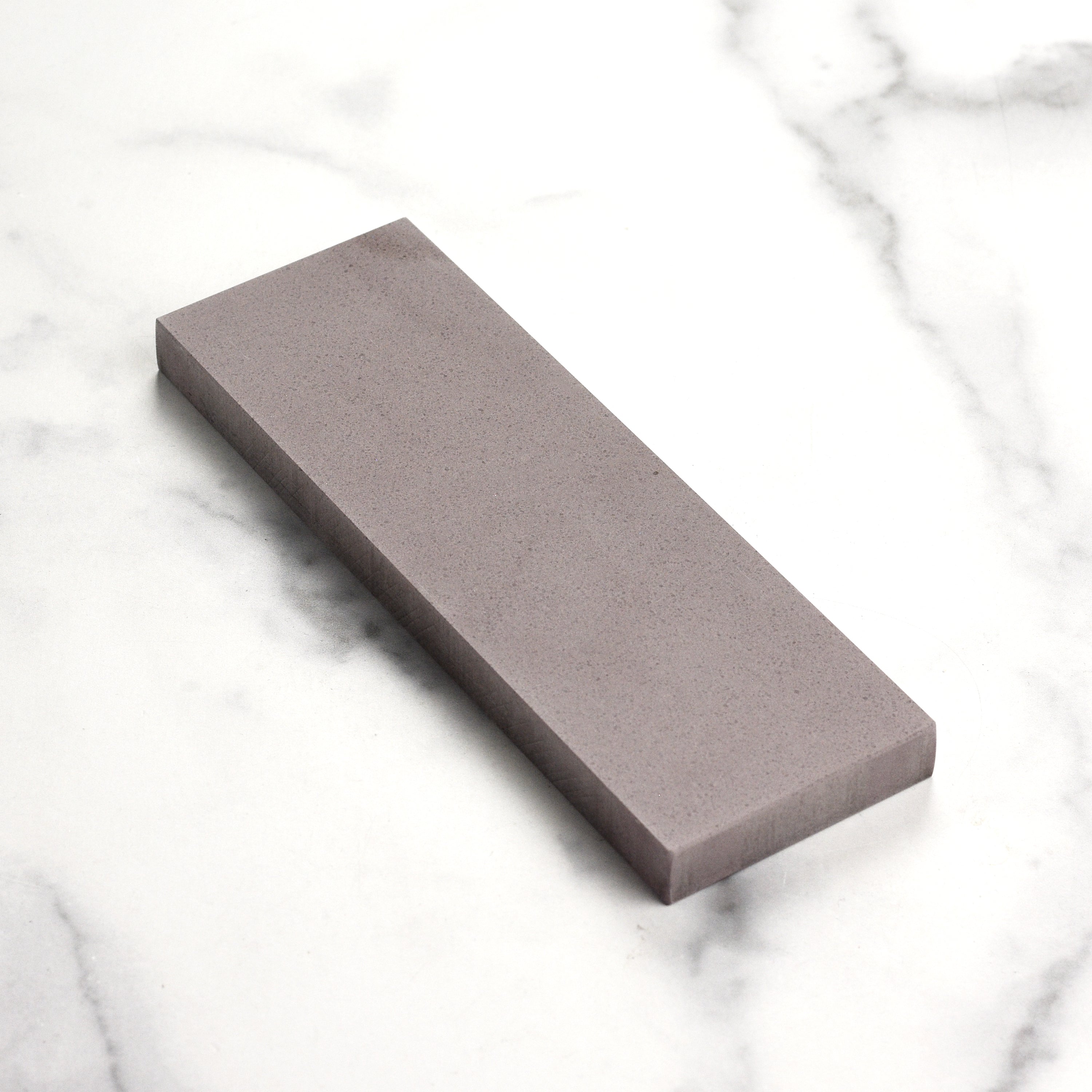 Shapton Kuromaku water stone being used to sharpen a high-quality kitchen knife.