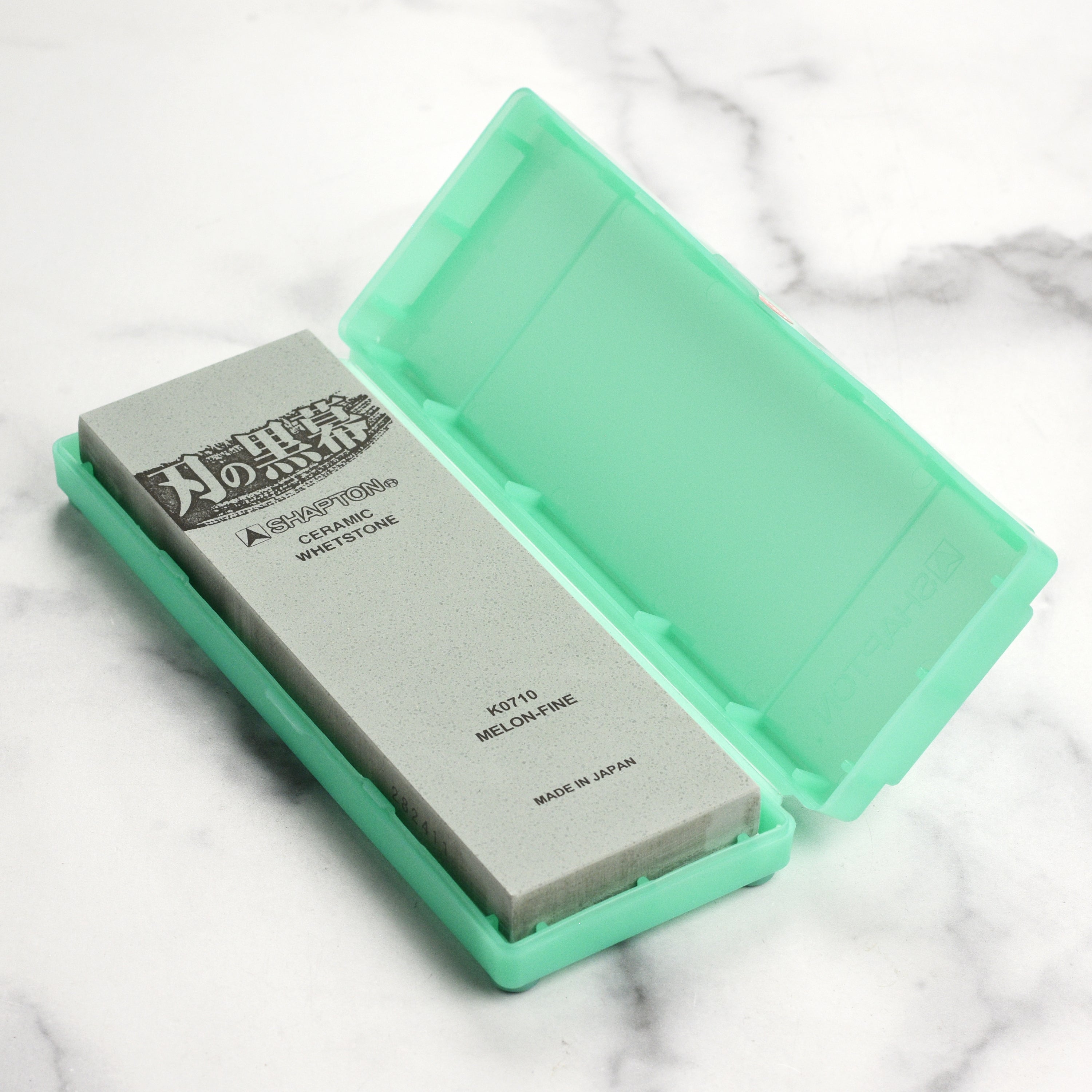 Shapton Kuromaku 8,000 grit sharpening stone with a kitchen knife, highlighting its fine finish.