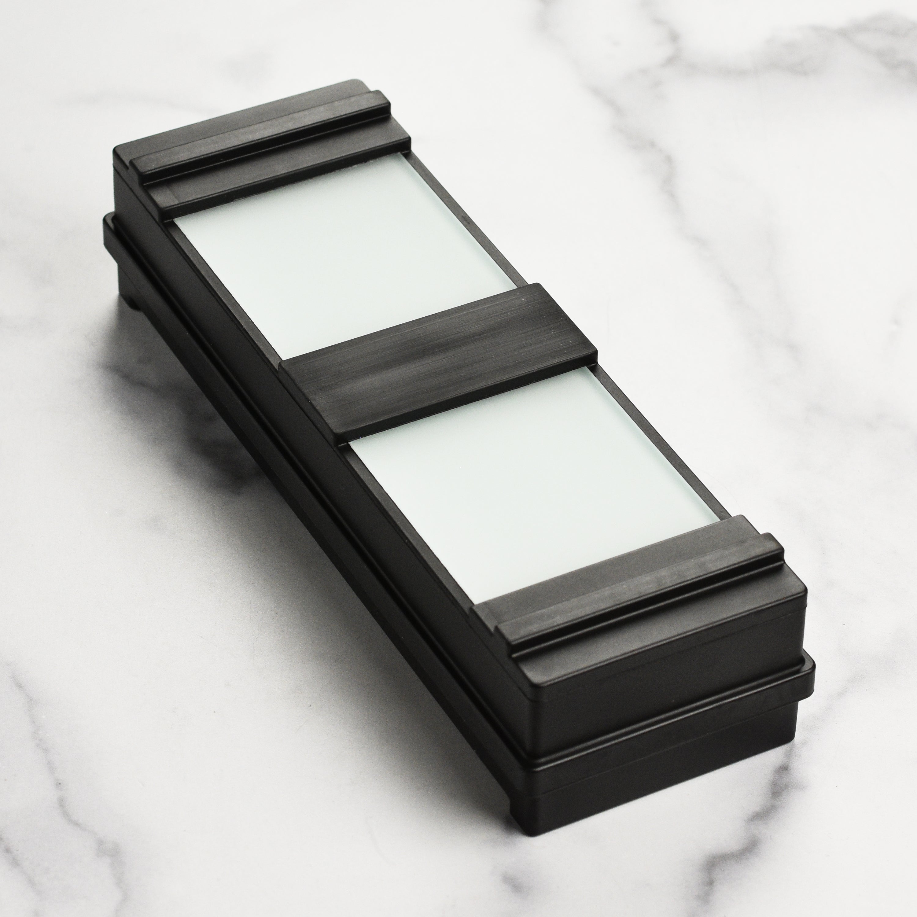 Top-down view of the water stone holder showing textured rubber casing and mounting grooves
