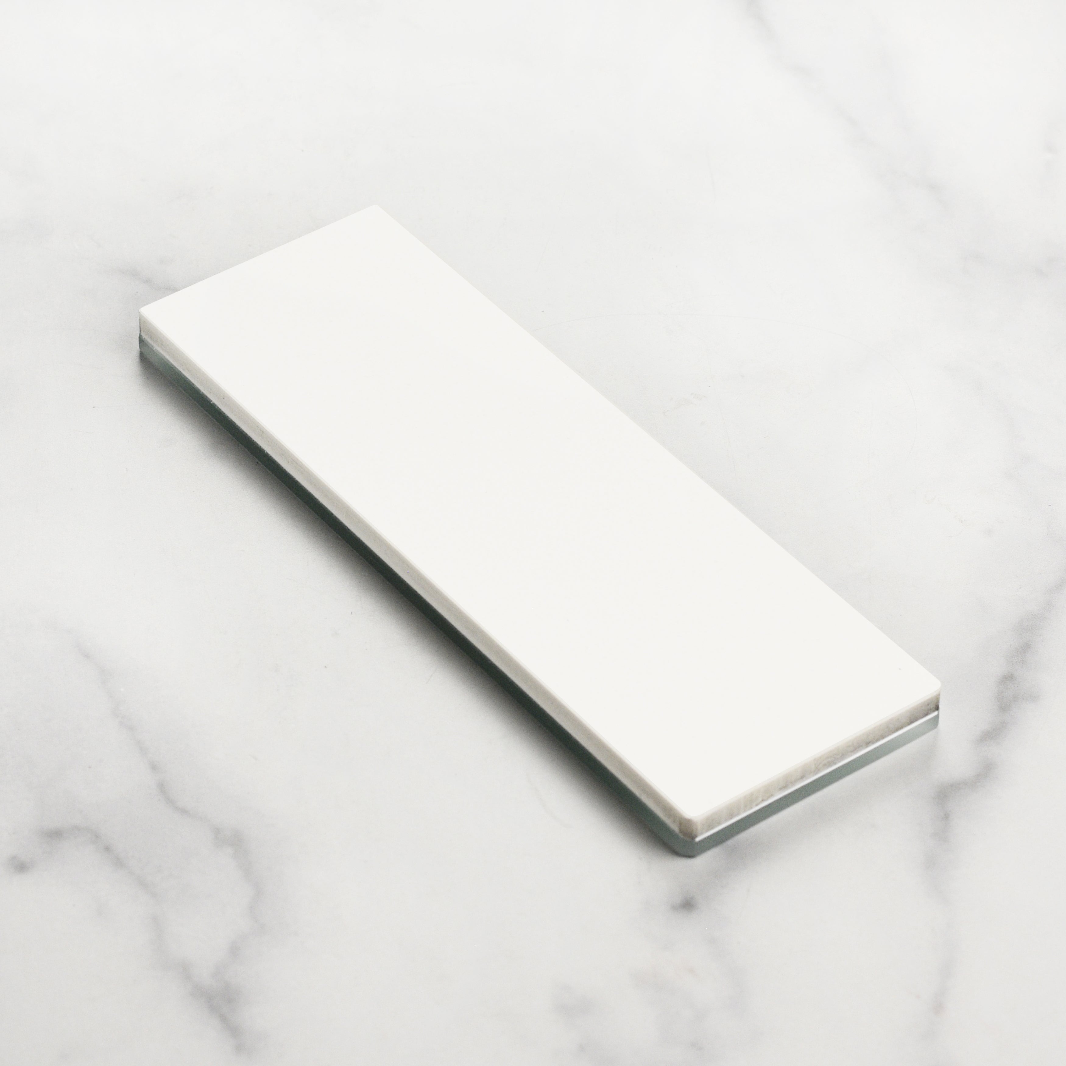 Close-up view of Shapton Glass 1000 Grit ceramic sharpening stone in use.