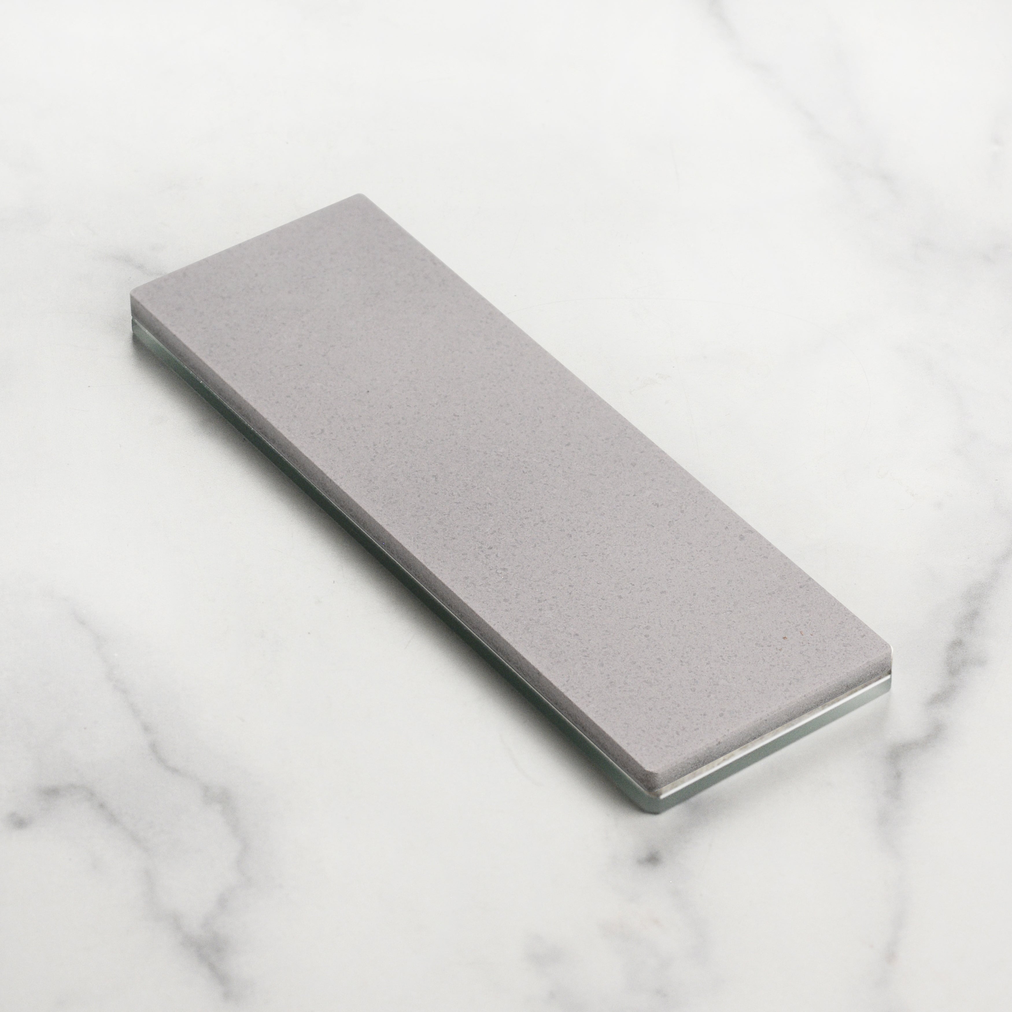 Close-up of the Shapton Glass Stone 220 grit showing the dense ceramic surface ideal for knife repair