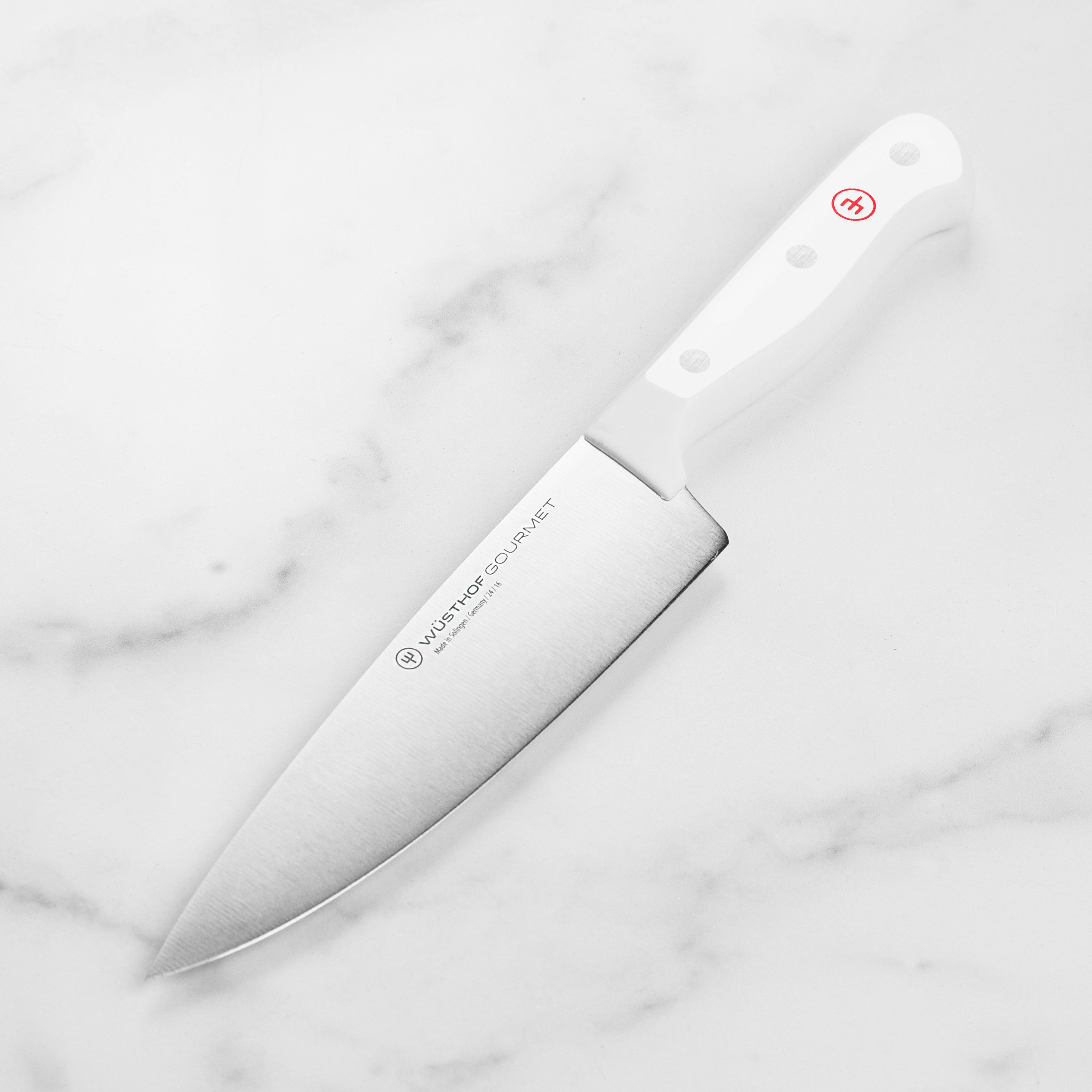 Wusthof Gourmet 6-inch knife with a sharp blade on a wooden cutting board.