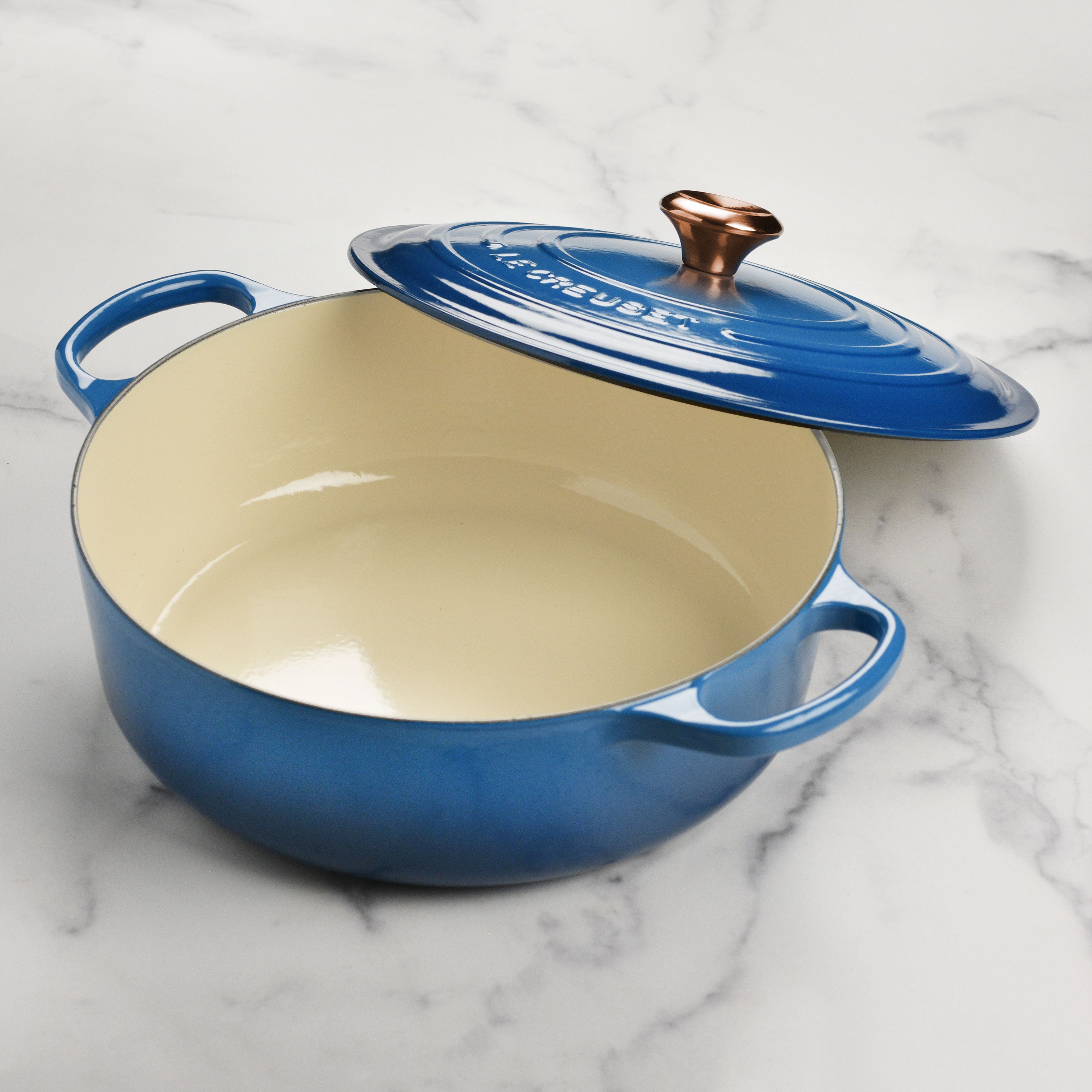 Close-up of the enameled Dutch oven lid with copper knob, showing high-quality craftsmanship