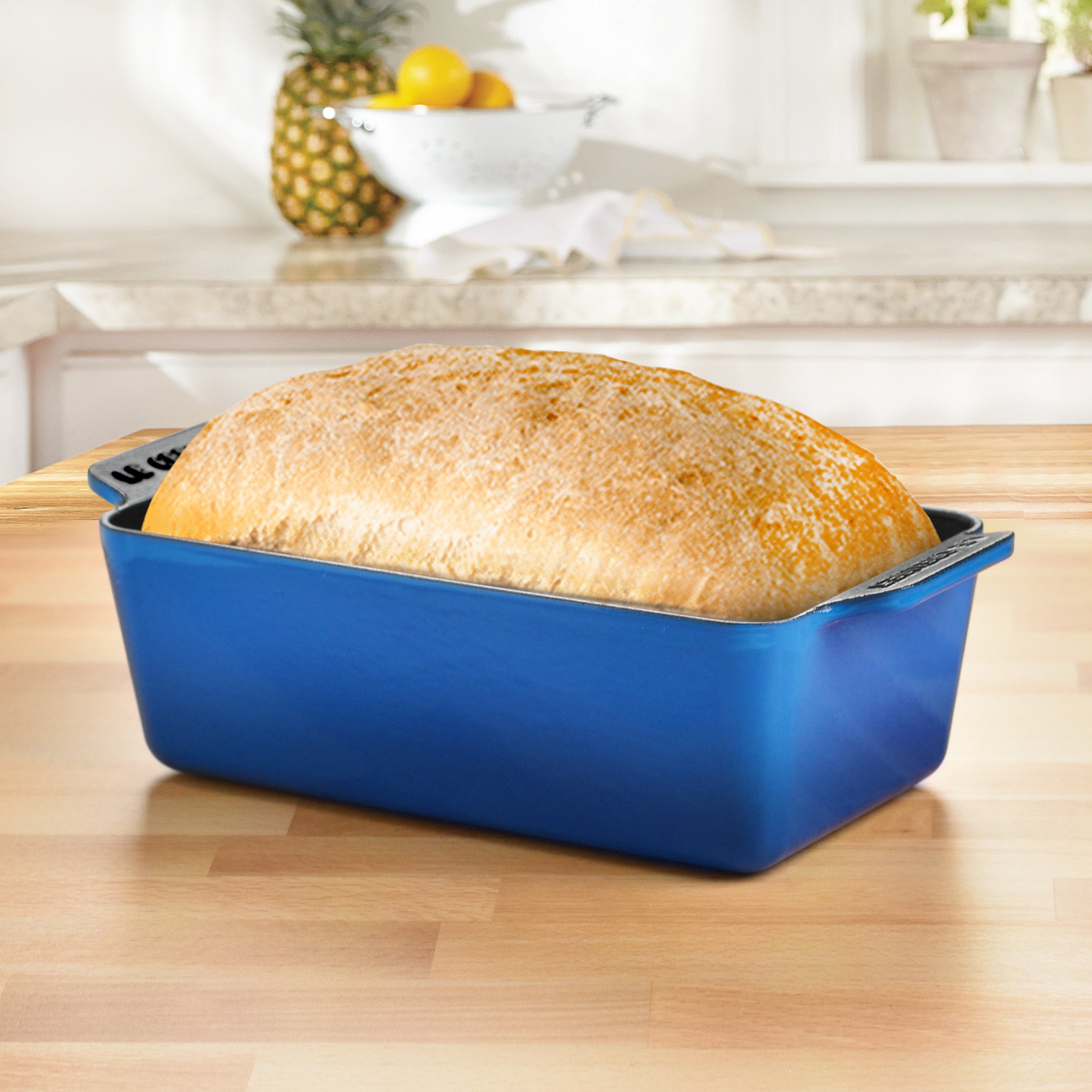 Close-up of the black satin interior enamel of the loaf pan with freshly baked bread inside