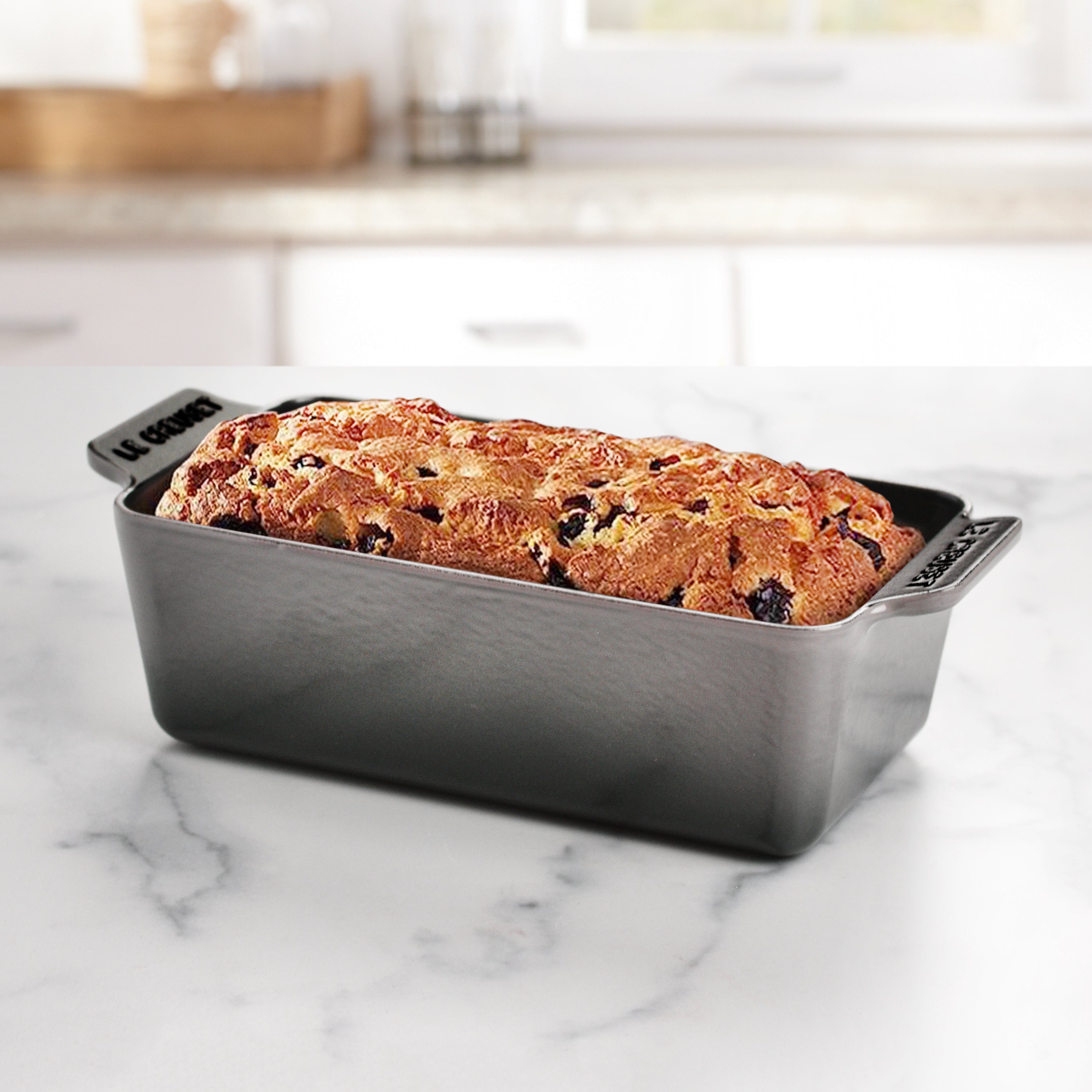 Close-up of the cast iron handles on the loaf pan, demonstrating easy lifting and transferring for baking enthusiasts.